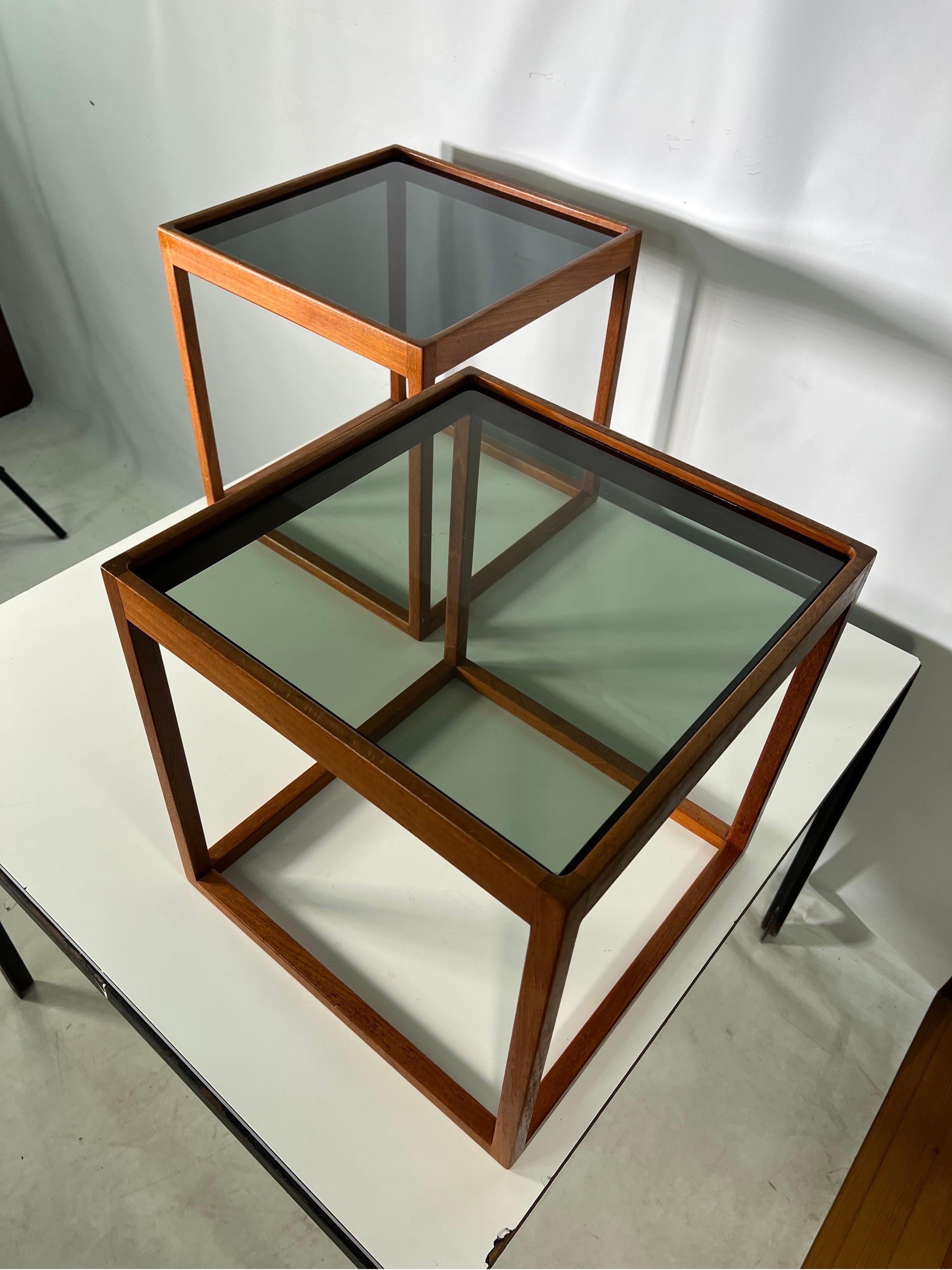 Paire de tables d'appoint cubiques du milieu du siècle par Kai Kristiansen. Les supports sont construits en teck avec des plateaux en verre fumé.