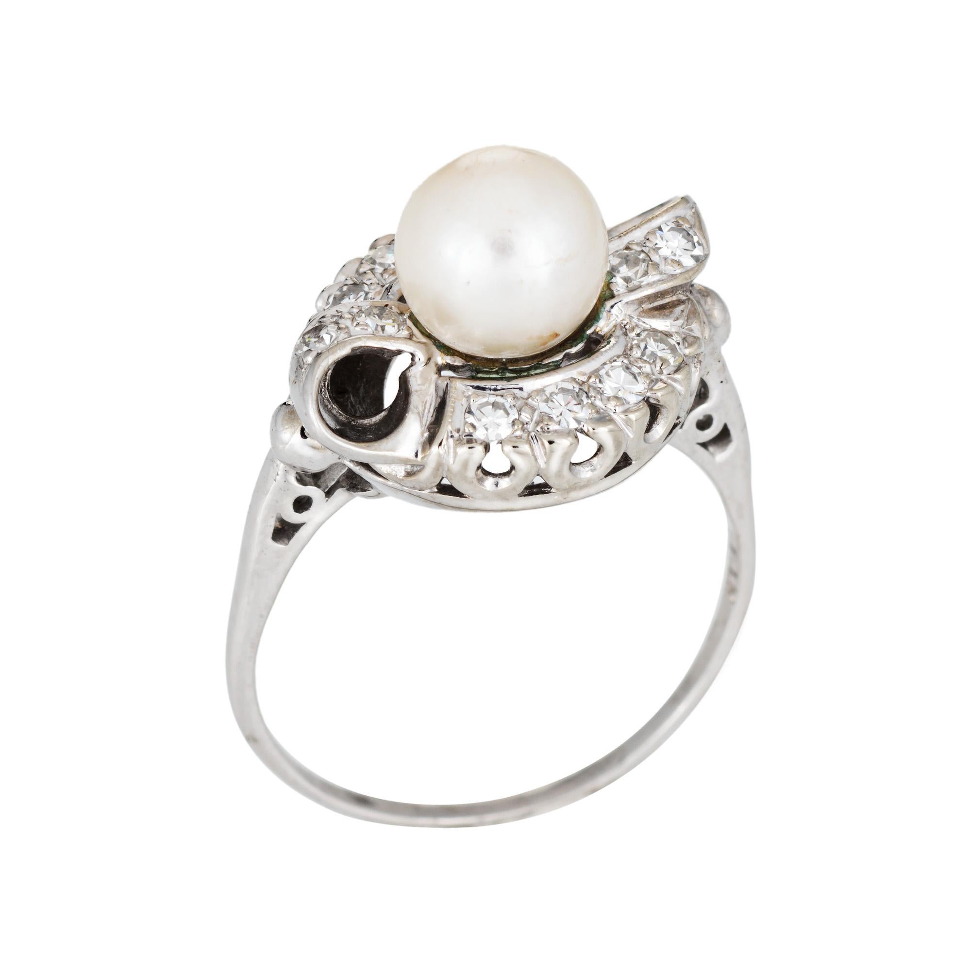 Stylish vintage cultured pearl & diamond ring crafted in 14 karat white gold (circa 1950s to 1960s). 

7mm cultured pearl is accented with an estimated 0.12 carats of single diamonds (estimated at H-I color and VS2-SI1 clarity.

The Mid-Century ring