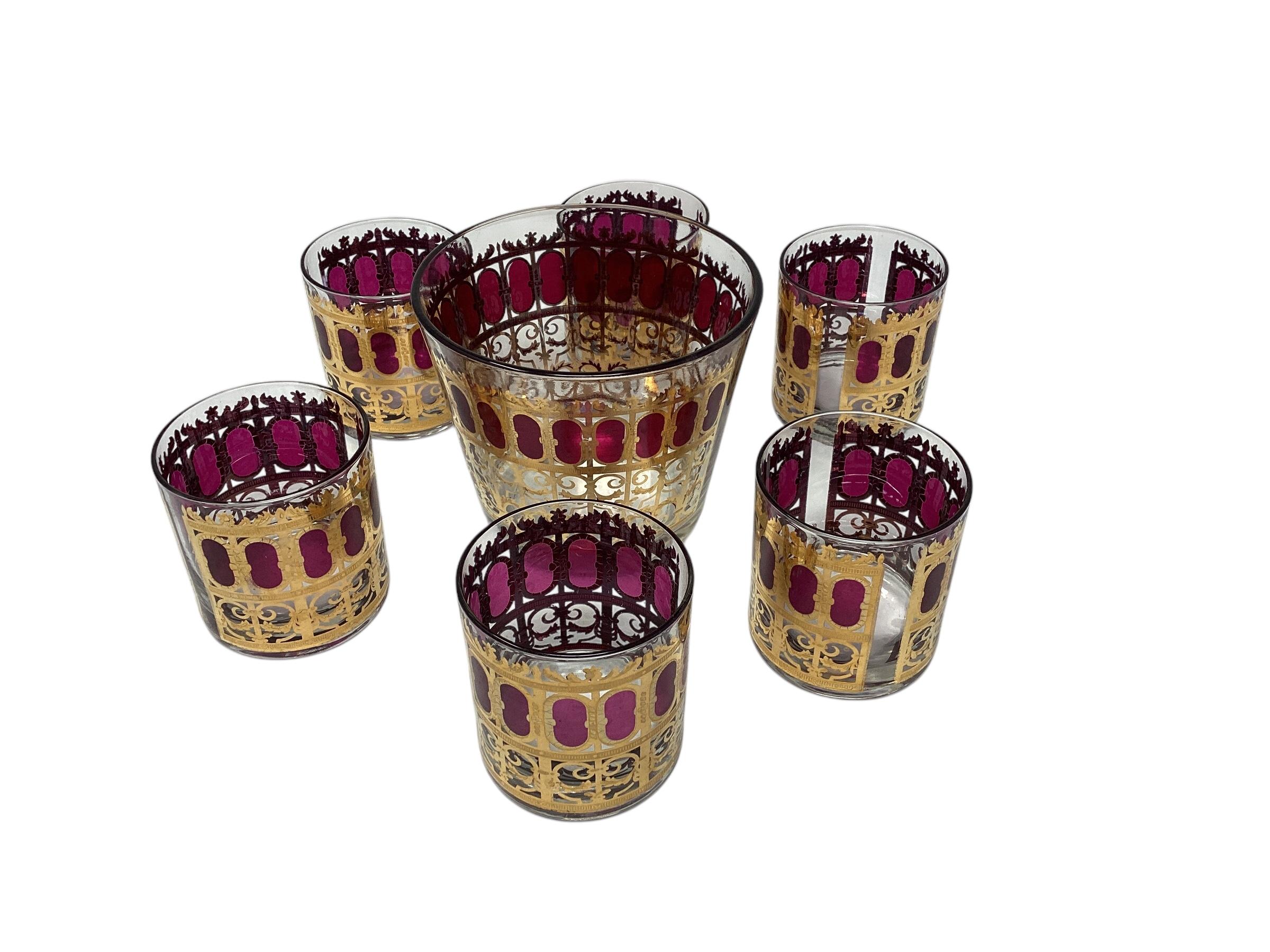Vintage Culver Cranberry Scroll Cocktail Set, 6 Rocks Glasses and Ice Bucket. 22-karat gold filigree scroll work in a Moorish inspired windows pattern with cranberry ovals filling each window. All in very good vintage condition.
Ice bucket 5.75 x
