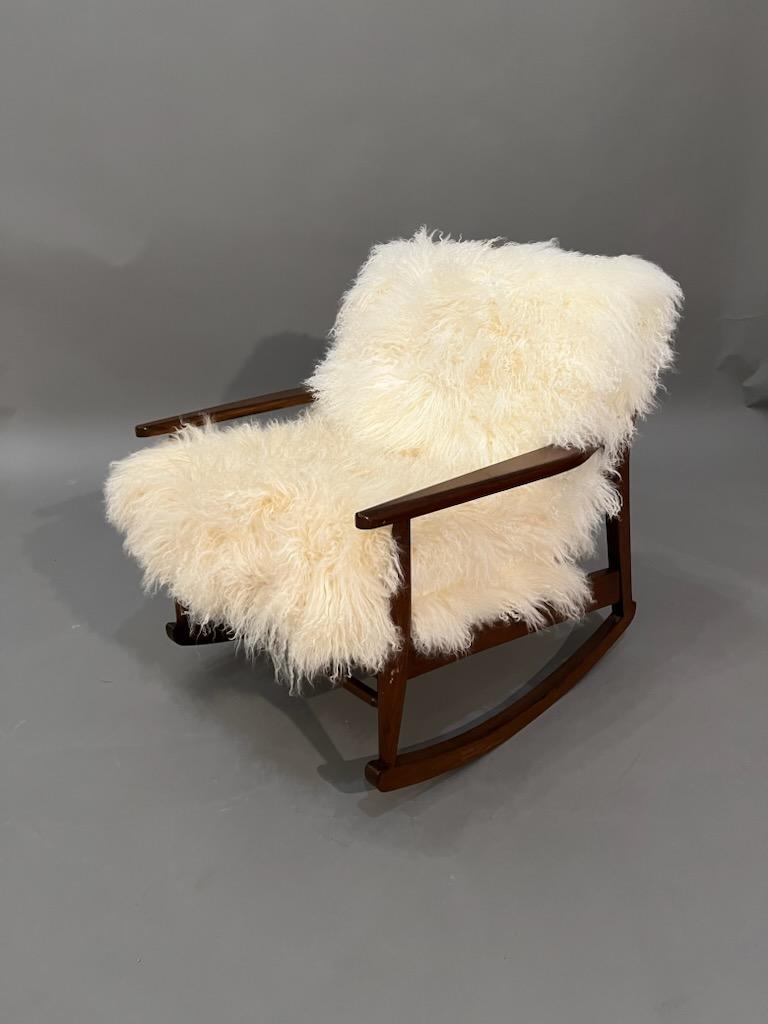 Mid-Century, Curated, Walnut arm Rocker lounge chair 1960s Circa completely restored with new Mongolian Fur Cushions off white/cream. 

Arm to Arm: 25” inches 
Interior depth: 20” inches 
Cushions thickness: 3.5” inches 
Seat hight: 16” inches