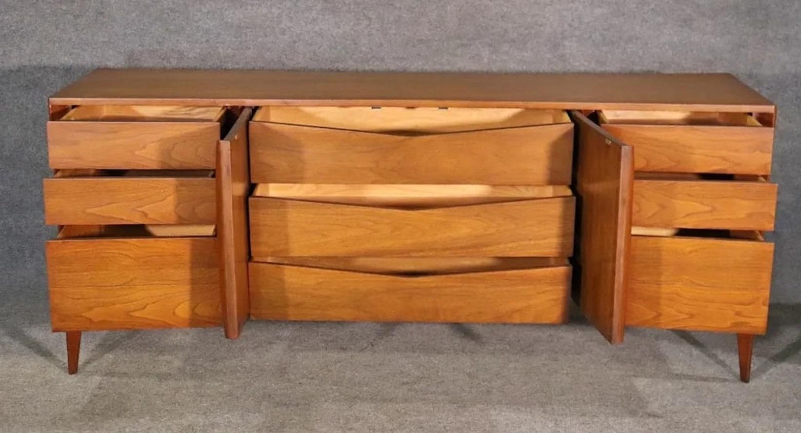Vintage walnut dresser by Unagusta with curved front. Nine total drawers, sculpted front doors and tapered legs.
Please confirm location NY or NJ