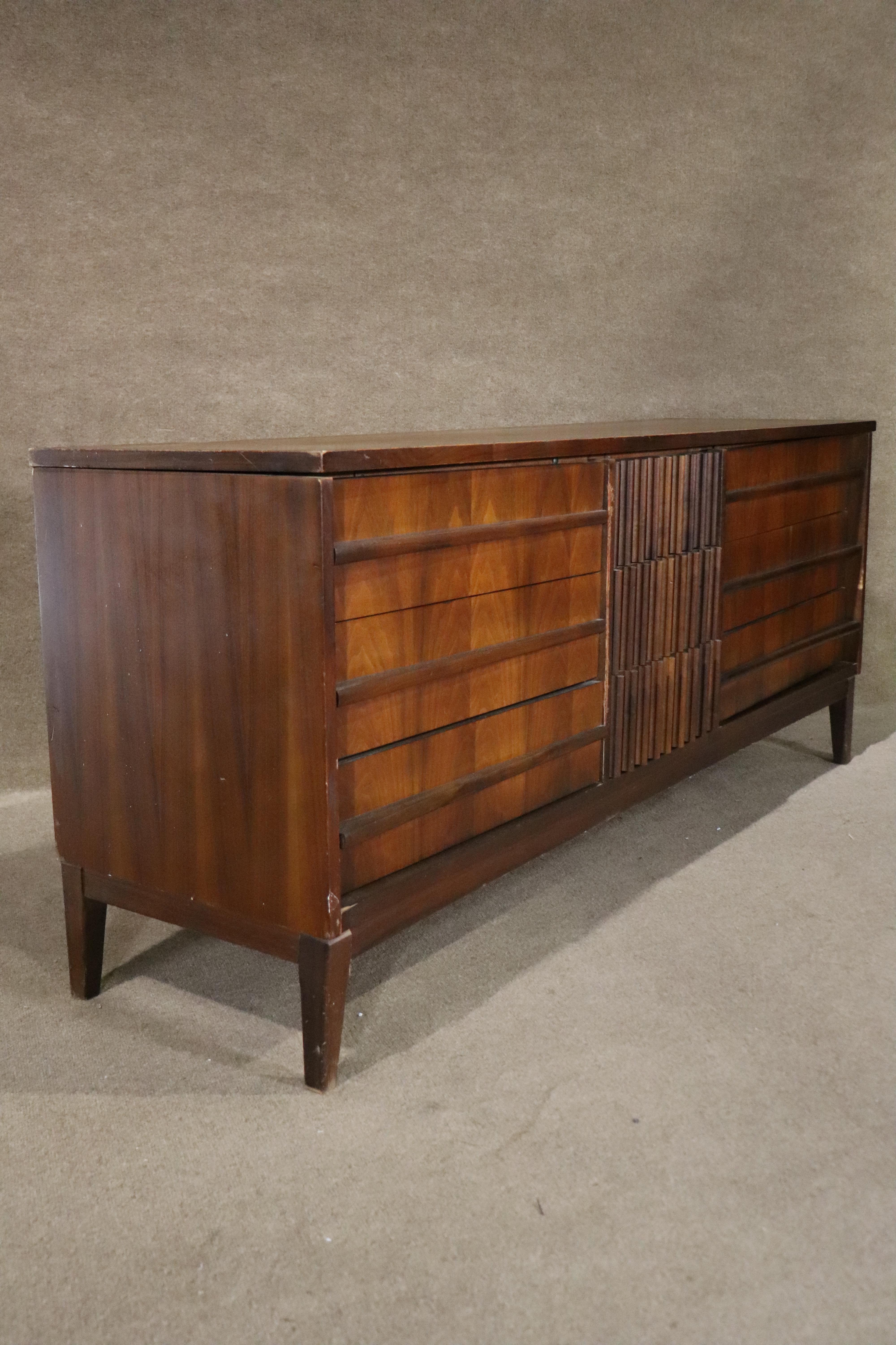 Long walnut dresser with curved front and matching mirror. Nine drawers with sculpted front design and burl wood.
Mirror: 52w, 36h
Please confirm location NY or NJ