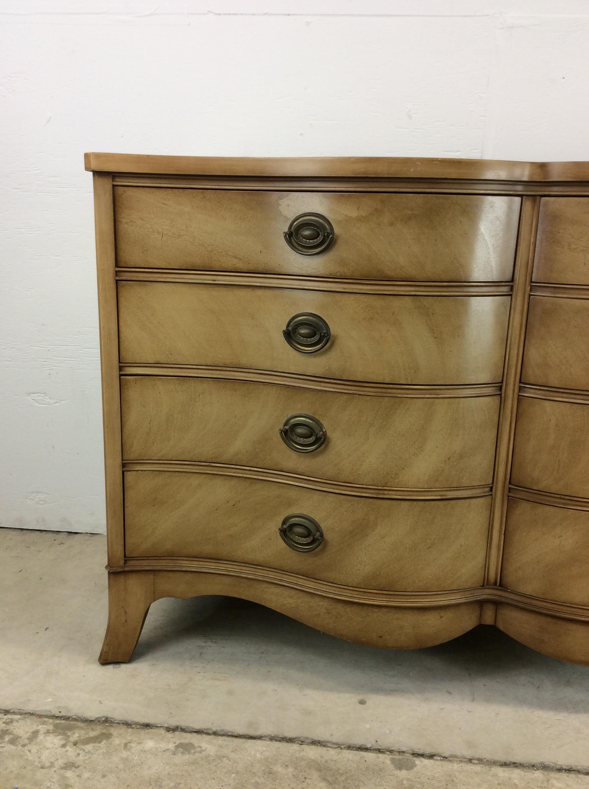 This mid century eight drawer dresser by Drexel features hardwood construction, bleached walnut veneer with original finish, traditional brass hardware, curved drawer fronts, and tapered legs.

Matching single nightstand, wall mirror & highboy