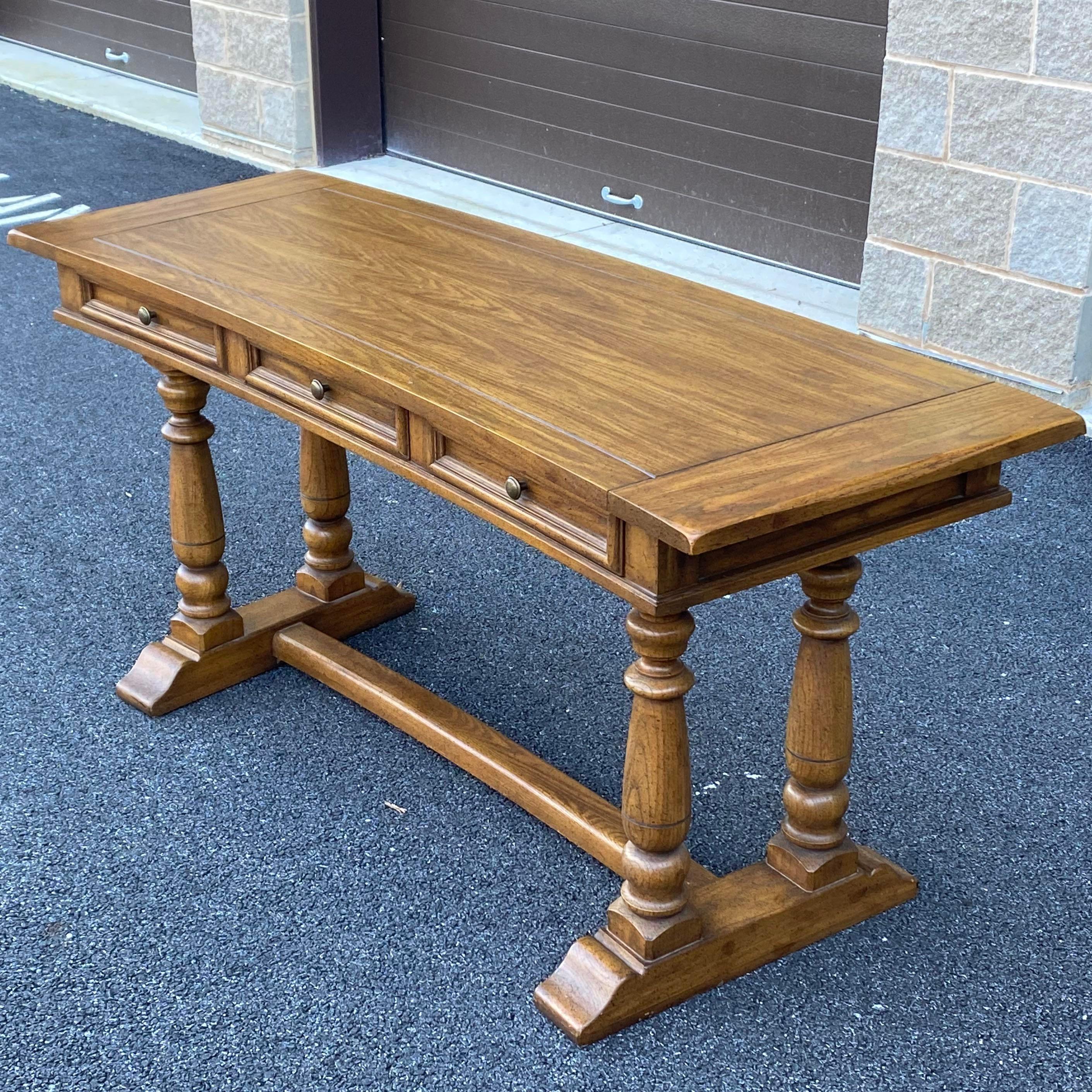 A high quality vintage writing desk featuring a curved top with three drawers on a trestle base from J.B. Van Sciver Company. The back is finished allowing for unlimited room placement possibilities! 