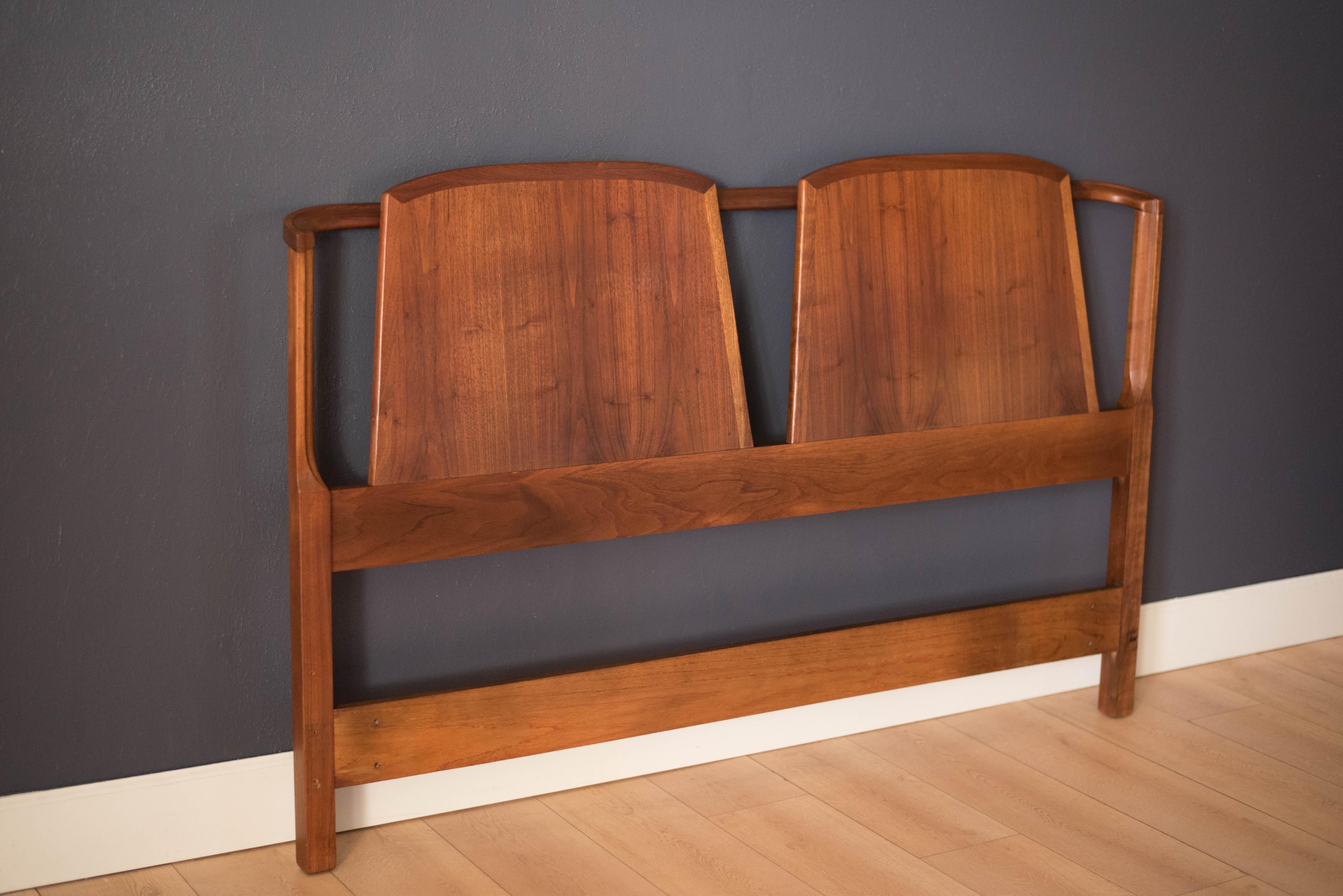 Vintage queen size headboard by Dillingham Manufacturing Co., circa 1960s. This piece features a walnut double back panel with a slim curved frame. Pre-drilled settings in place for bed frame attachments.