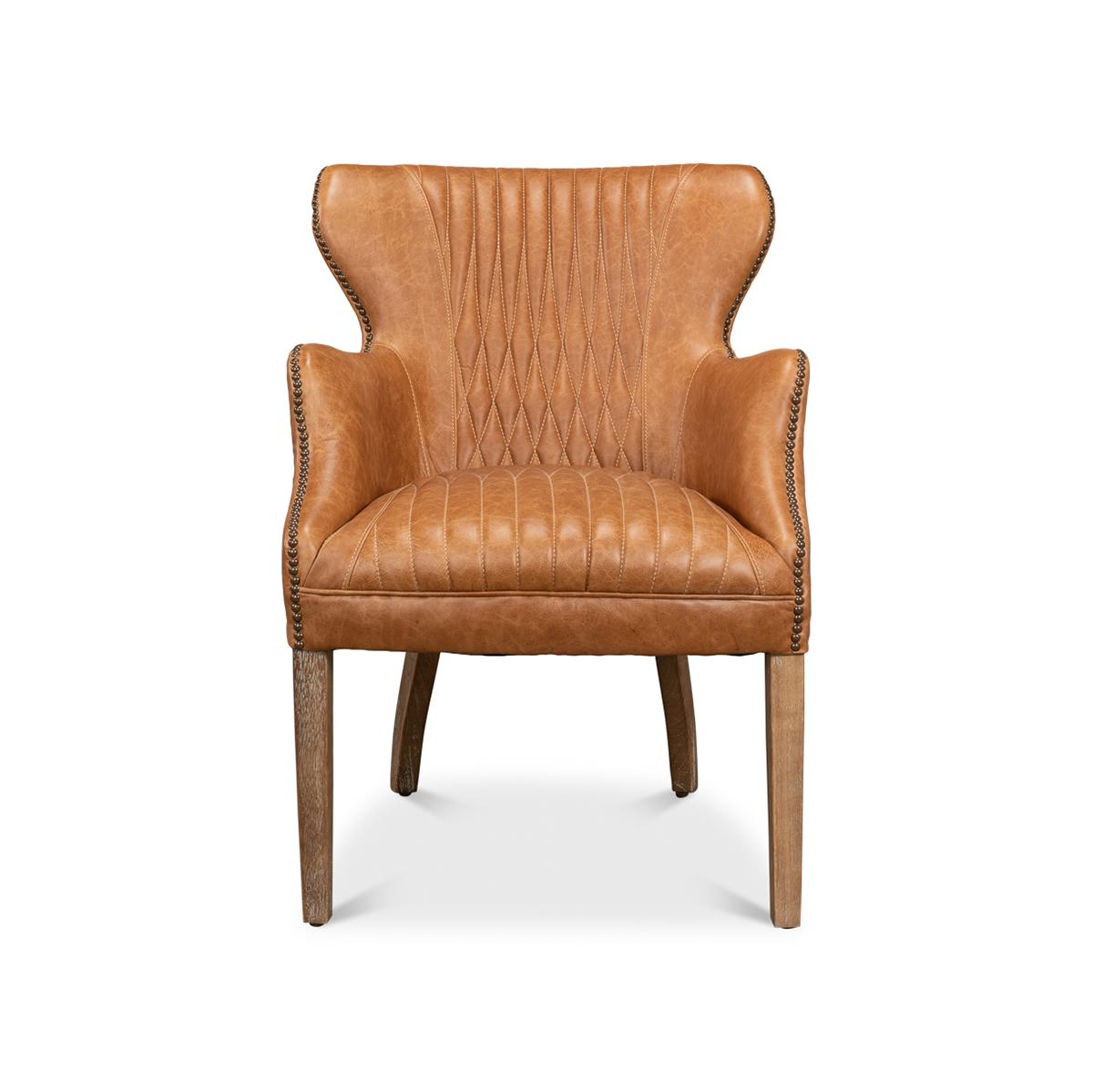 A Mid-century inspired curved wing leather armchair with nailhead trim accents. This beautiful chair is crafted with pure Aniline top-grade leather in a tan transitional color. It has slightly curved wings and arms outlined in with classic nailhead