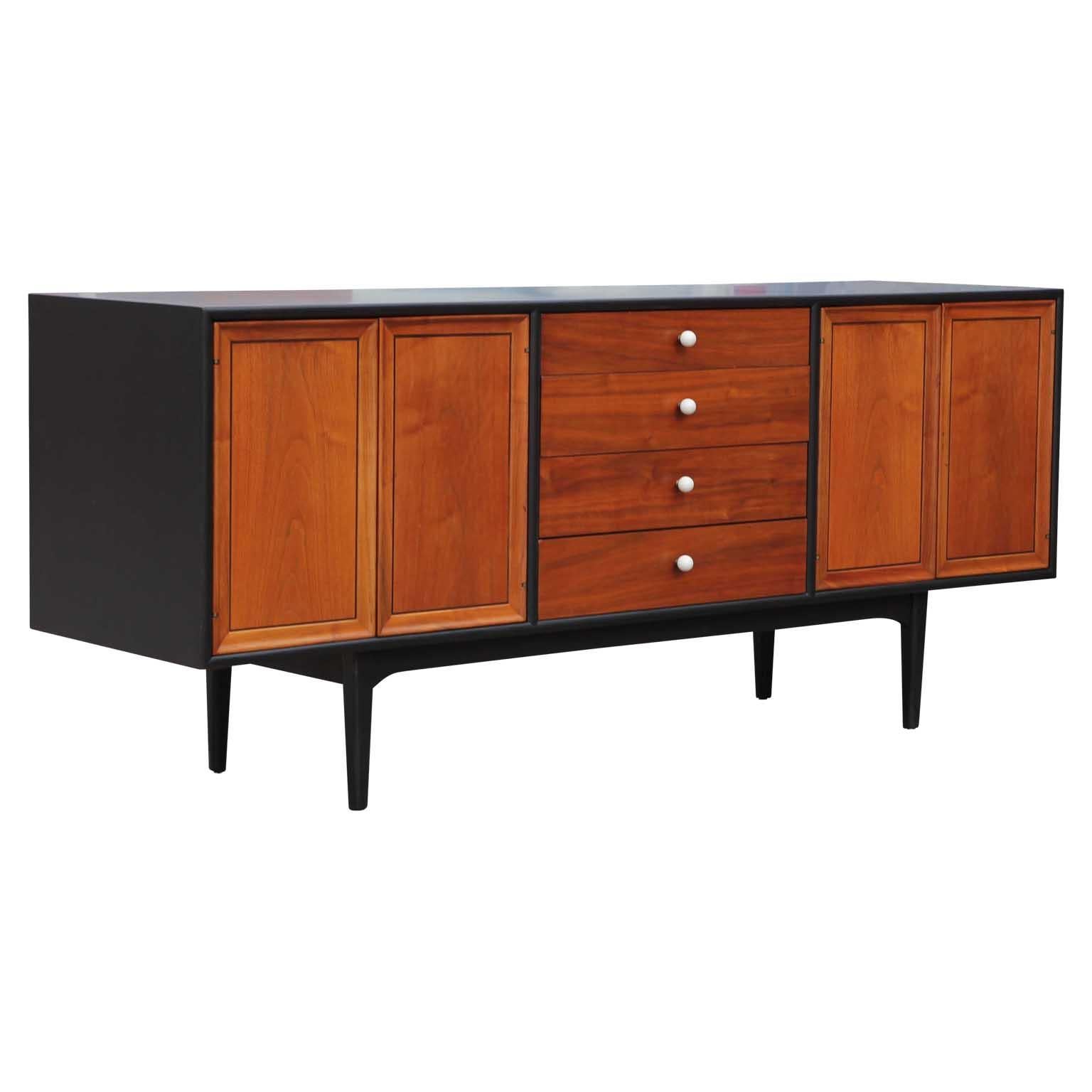 Midcentury Drexel declaration credenza by Kipp Stewart and Stewart McDougall featuring four center drawers accented by white porcelain pulls, with double door storage compartments on both sides has been customized with black and natural wood finish.