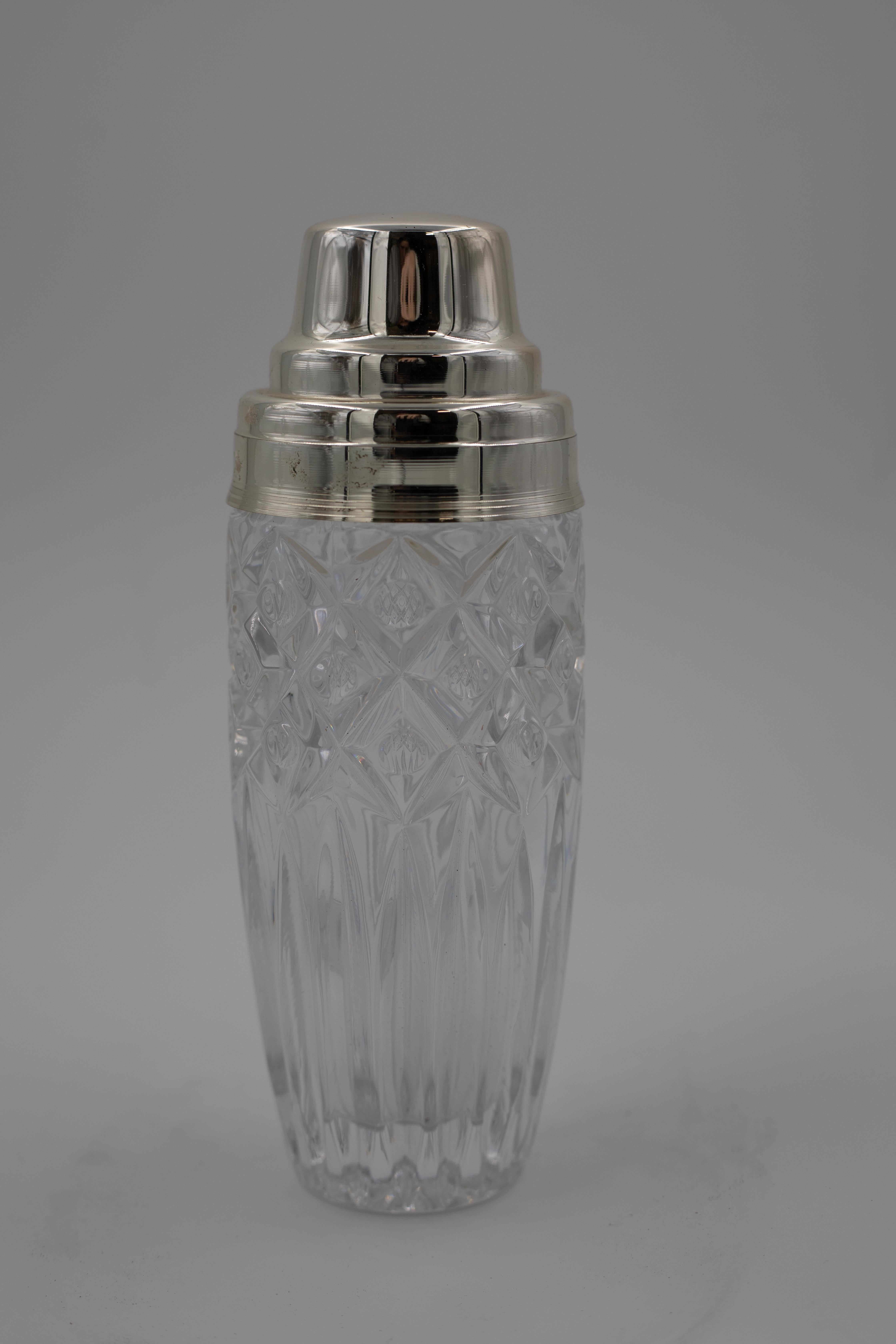 Ein wunderschön gearbeiteter Cocktailshaker aus der Mitte des 20. Jahrhunderts mit einem detailreichen Körper aus geschliffenem Kristall mit einer Kombination aus tiefen Diamantschliffen und länglichen vertikalen Rillen. Der massive Kristallsockel