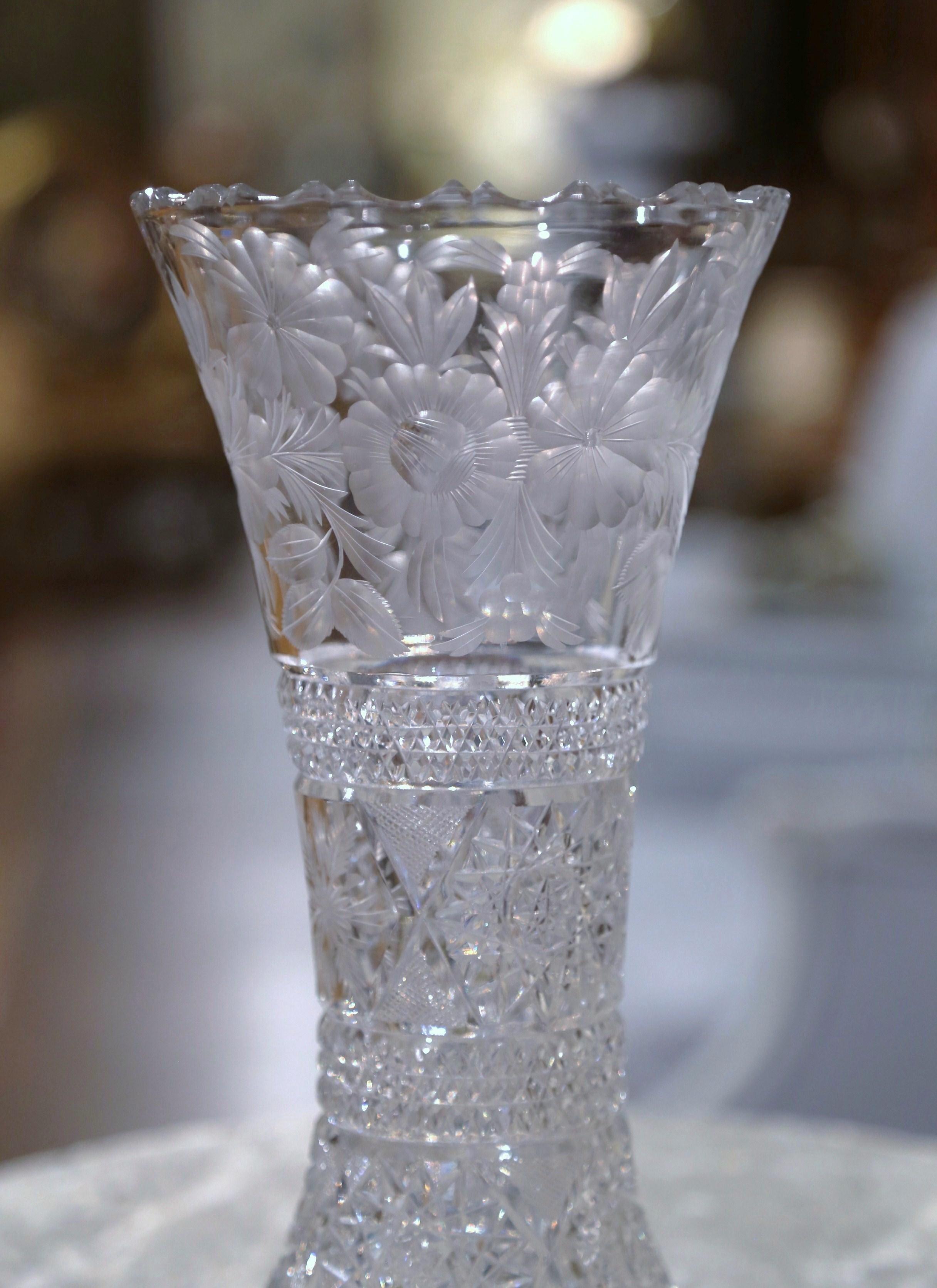 Decorate a console or buffet with this elegant crystal trumpet vase with scalloped rim. Crafted in France, circa 1960 and round in shape, the large luxurious cut glass vessel is decorated throughout with geometric and star decor; the vessel is