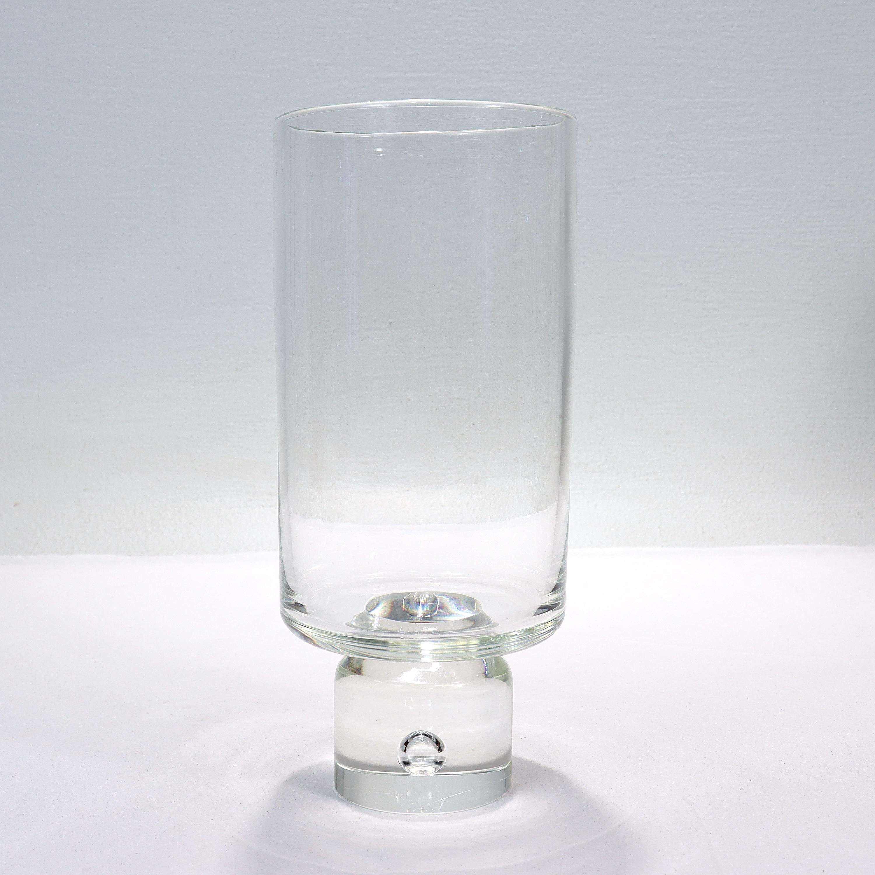A fine Mid-Century Modern art glass vase.

By Steuben.

With tall, cylindrical side walls supported by a solid cylindrical base containing a captured bubble.

Simply great Mid-Century American design! 

Date:
Mid-20th century

Overall
