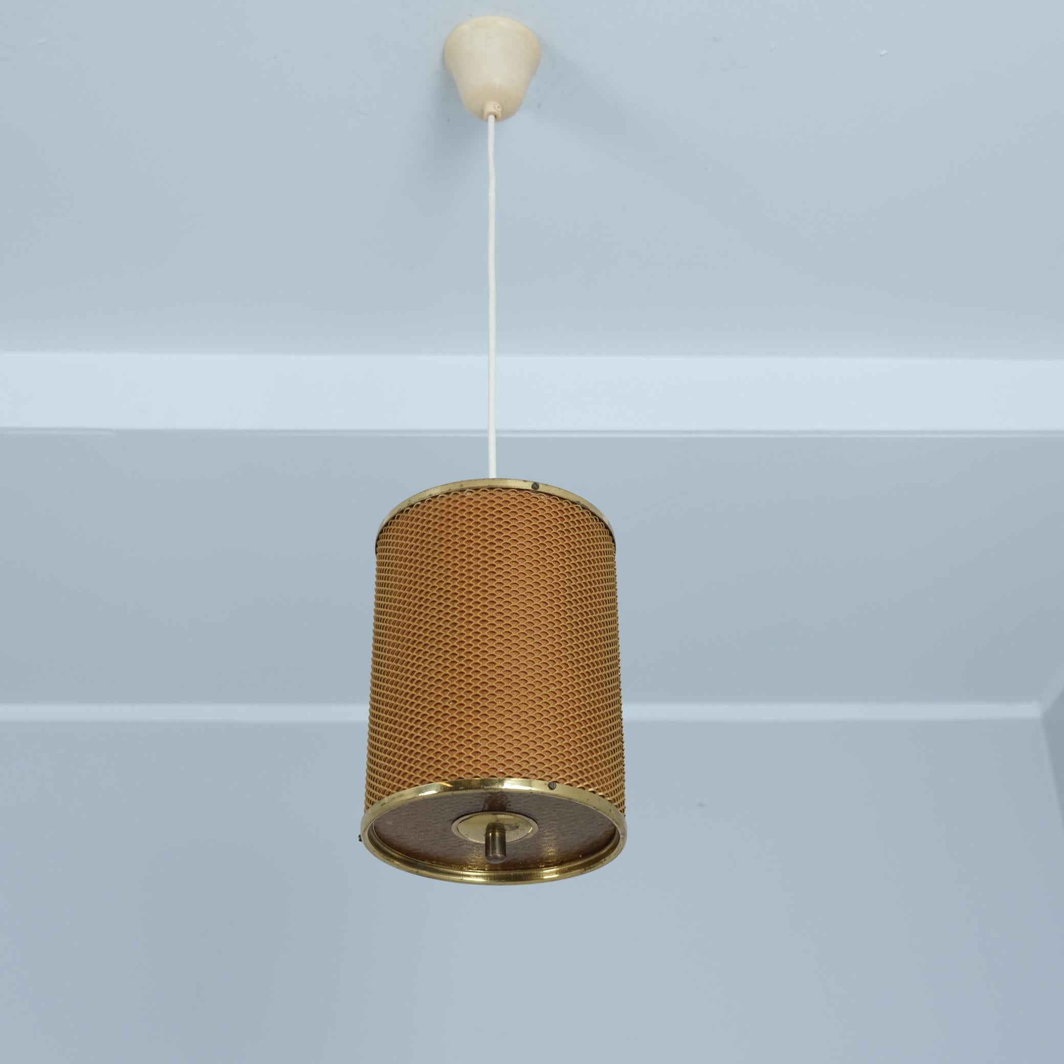 A beautiful Mid-Century Modern cylinderical ceiling lamp model no. 2210  from the 1950s by the Finnish company Valinte which was one of the leading lighting manufacturers in Finland. The lamp features a cylinderical shaped shade made of brass rings
