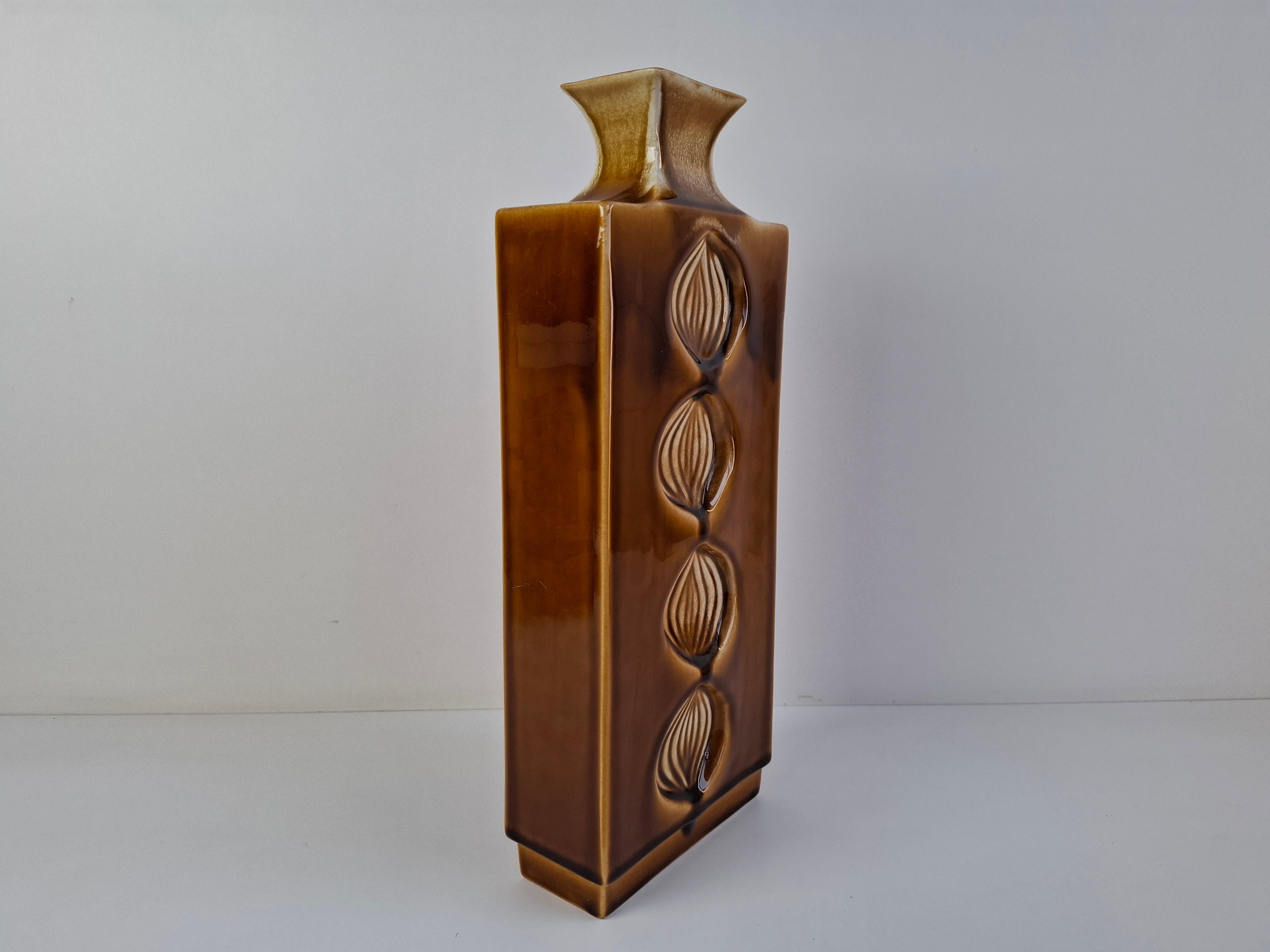 Questo sorprendente vaso in ceramica di metà secolo di Ditmar Urbach esemplifica le audaci forme scultoree caratteristiche del modernismo dell'Europa centrale. Prodotto in Cecoslovacchia, il pezzo presenta un caldo smalto marrone caramello