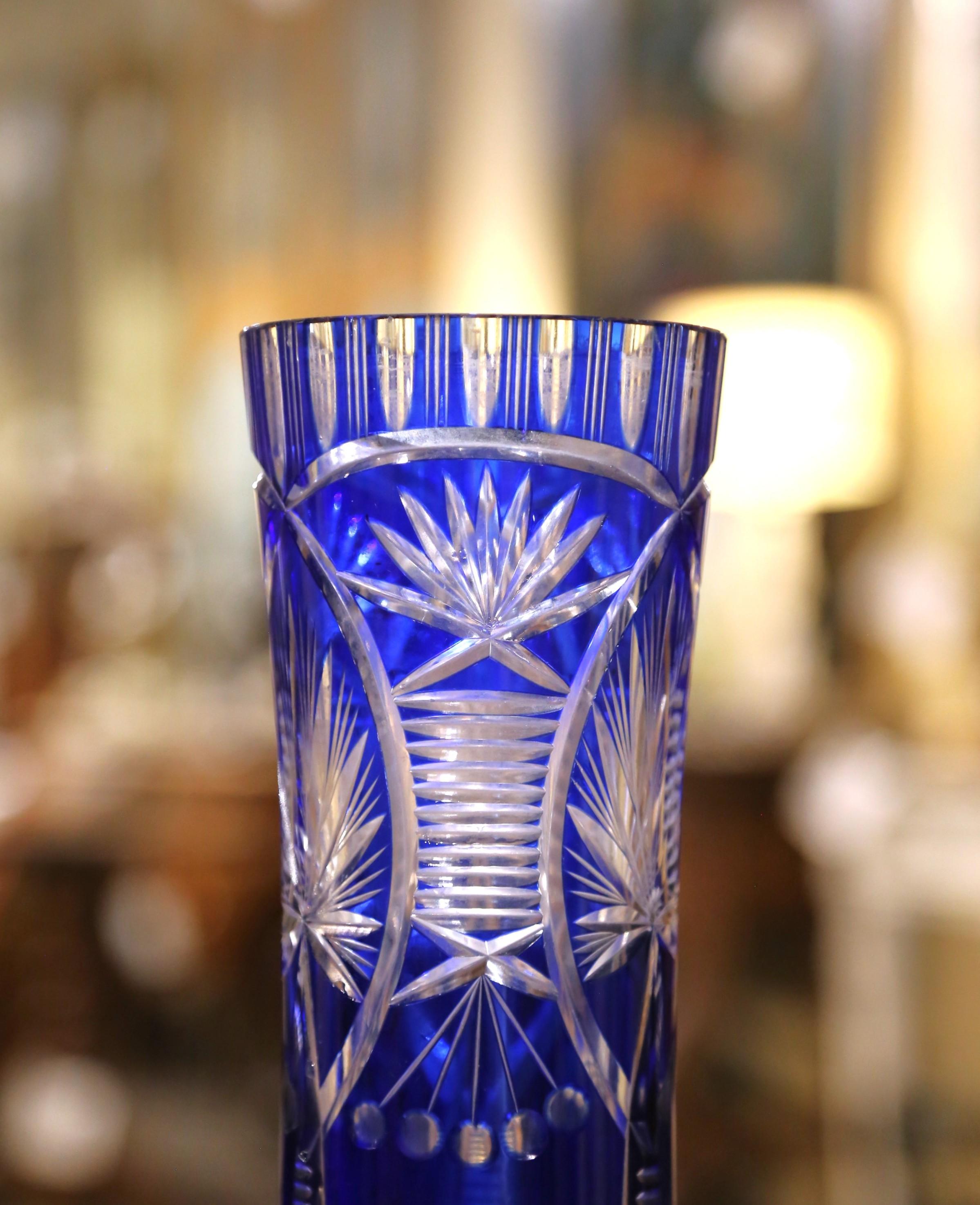 Showcasing the timeless brilliance of Bohemian craftsmanship, this strikingcirca 1950  Czech crystal vase is a fine example of cobalt cut-to-clear glass. The tall, flared form is richly decorated with deeply engraved geometric and botanical
