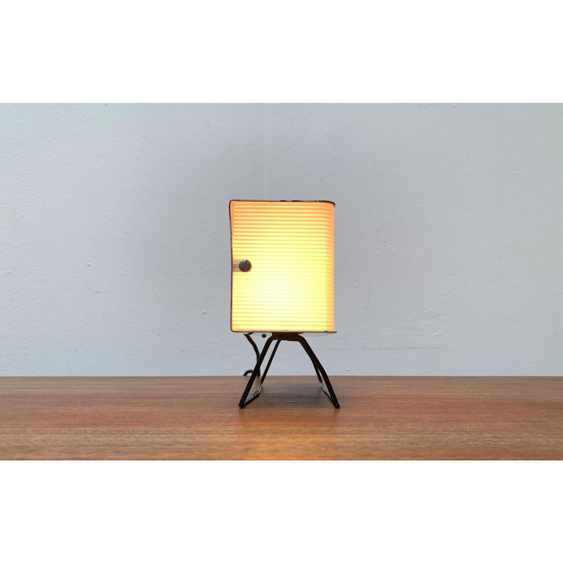 Rare Mid-Century table lamp from the Czech manufacturer Pokrok.

The design convinces with its clear construction. The form and materiality is characteristic of minimalism Czech lights from the era. The housing consists of a grated, black painted