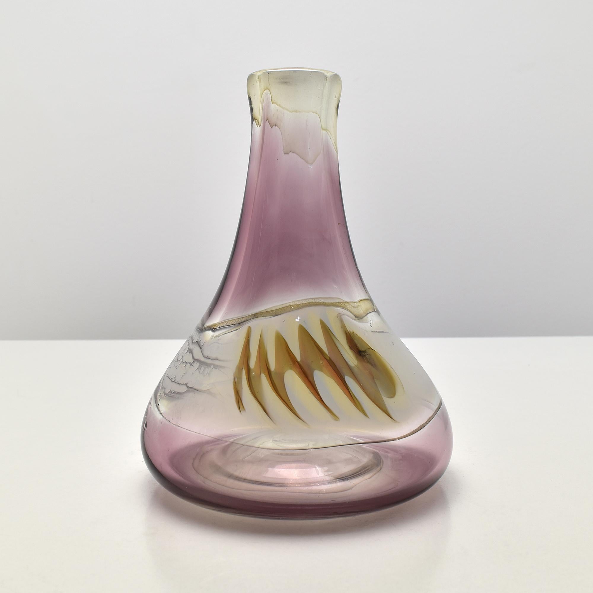 This striking mid-century Czech studio glass vase, created by Atelier Molnar and dating to the 1980s, showcases the expressive artistry that characterizes the region’s finest studio glass. Hand-blown in a soft gradient of amethyst-pink transitioning