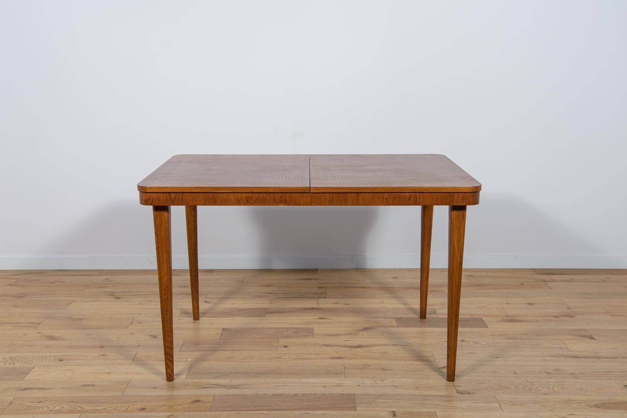 Extendable table manufactured by the furniture factory UP Zavody in Brno. The table is made of beech wood and ash and oak veneer. The table after a comprehensive carpentry renovation, cleaned of the old surface, painted with a oak stain, finished
