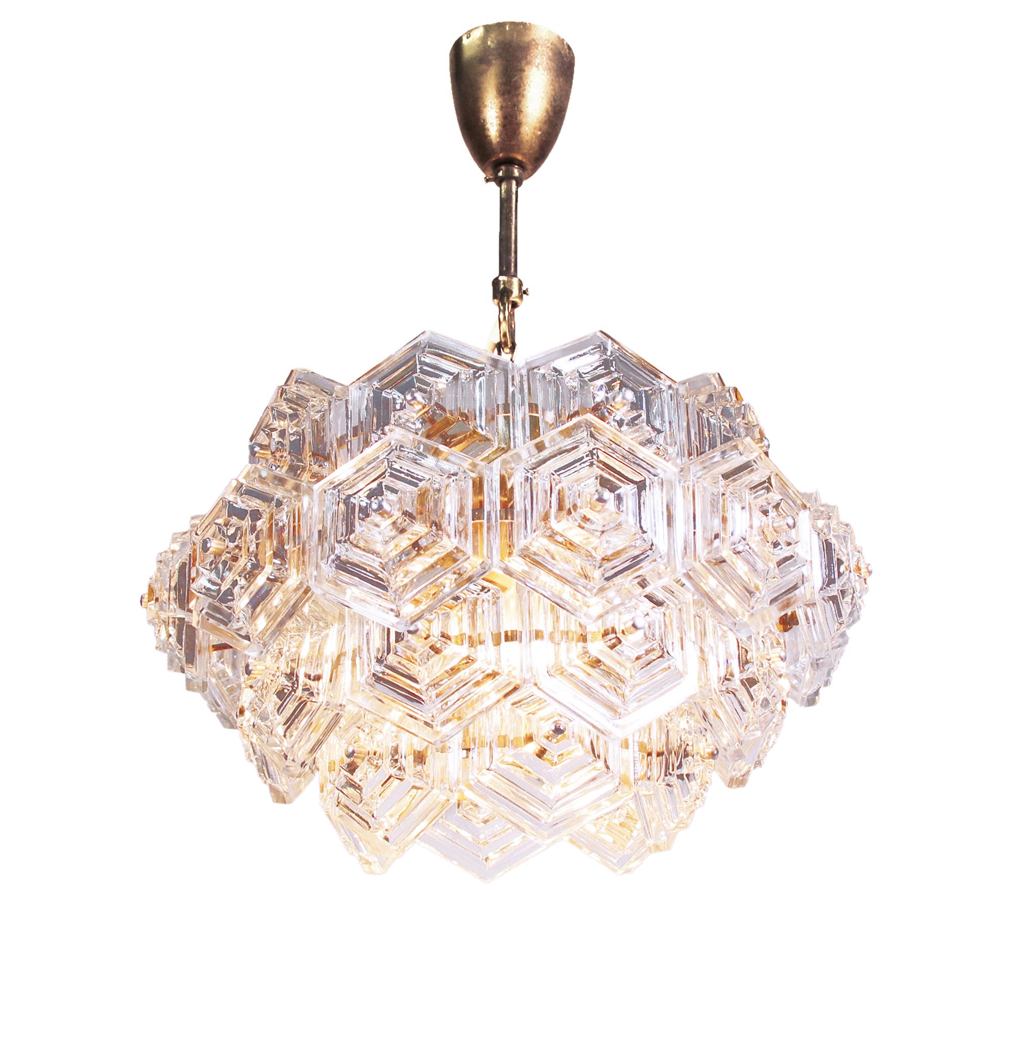 Dandelion chandelier with hexagonal glass prisms on a brass frame made by VEB Kristall Leuchten in the GDR in the 1960s. 

Lighting: The lamp takes three large Edison E27 base bulbs. 
Measures: dm 16.5 in. / 42 cm, height 10.2 in. / 26 cm,