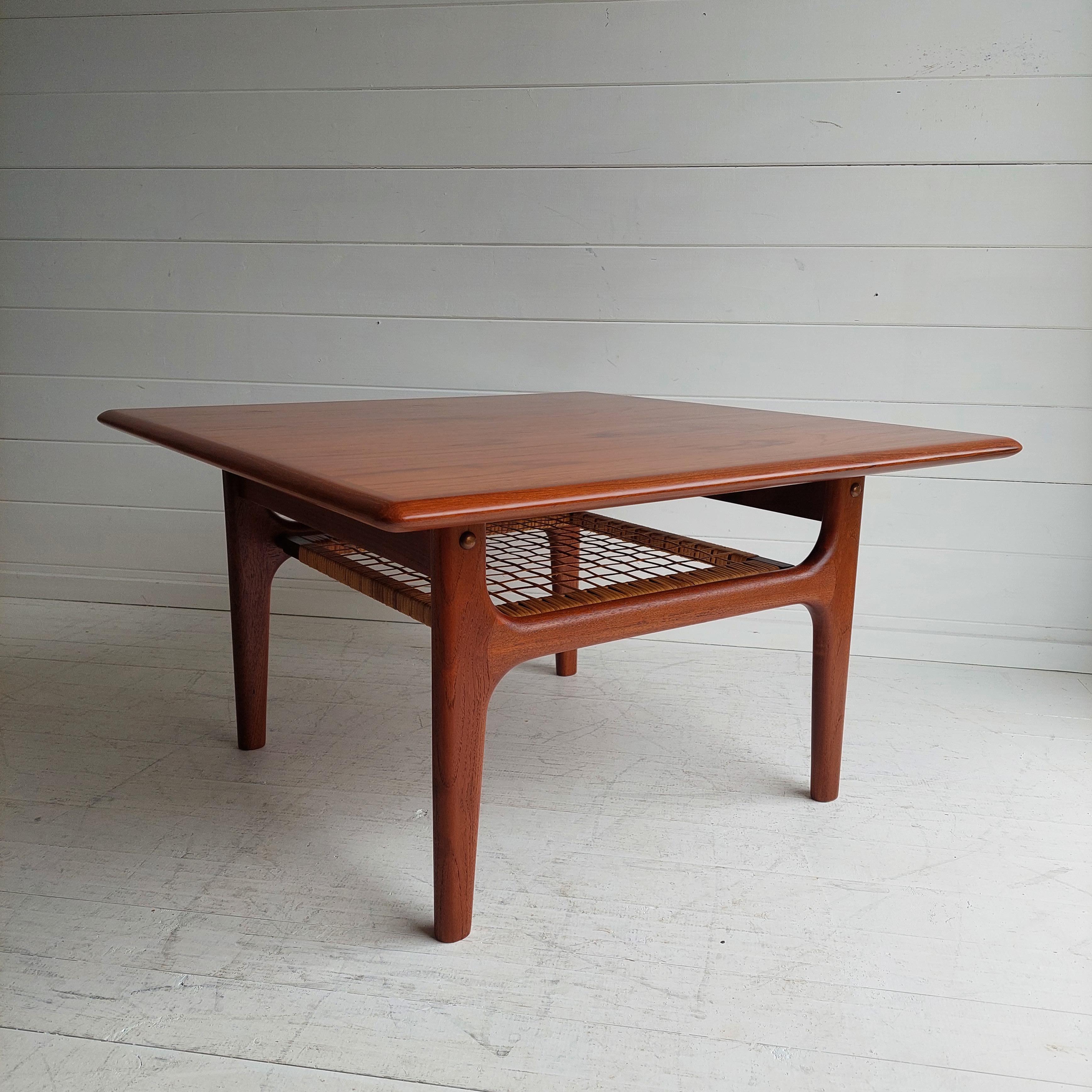 1960s Danish Mid-Century Modern teak coffee table features quality Scandinavian construction with a second cane tier for added storage for books or magazines. 

This coffee table is very stylish and would look great in any midcentury home or even