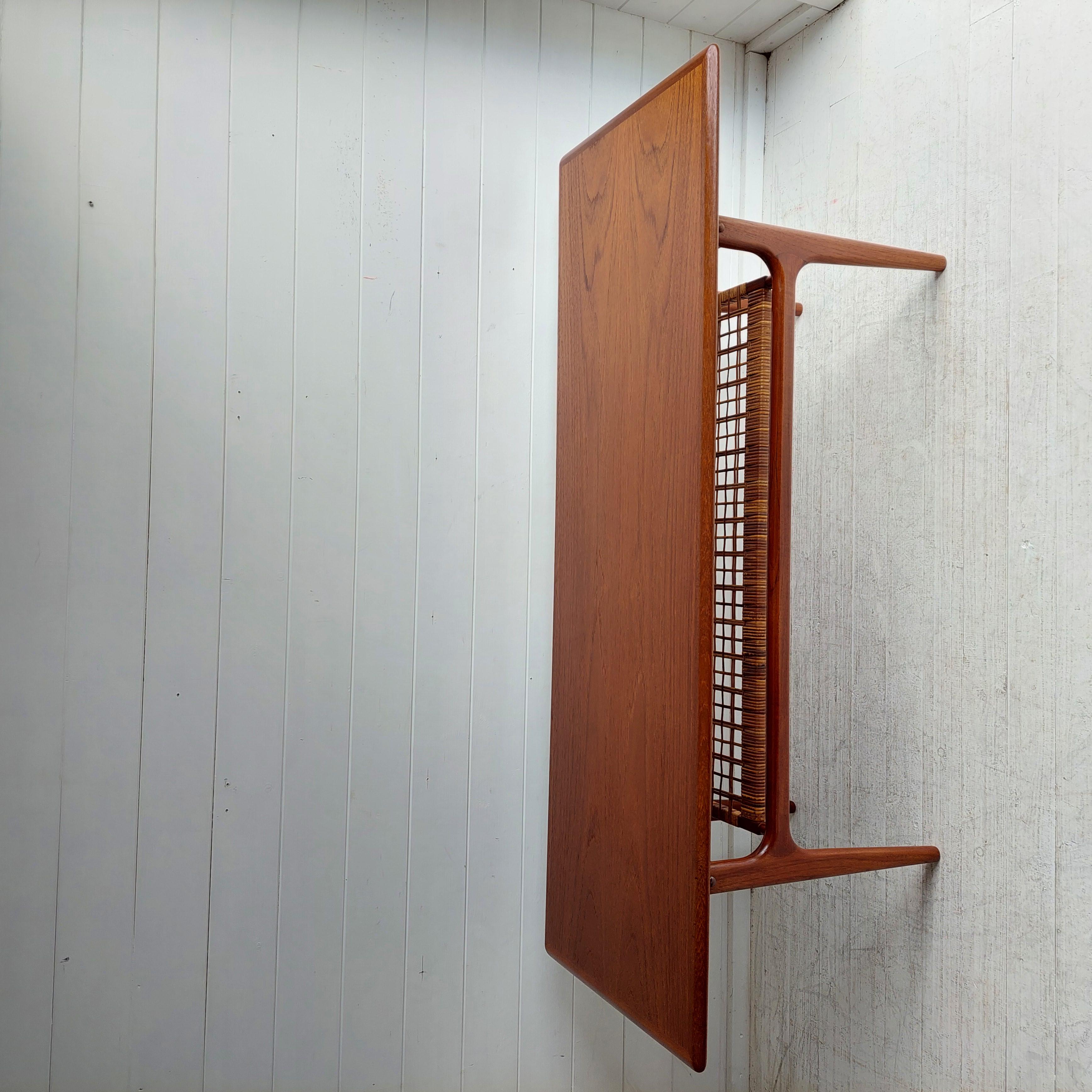1960’s Danish mid century modern teak coffee table features quality Scandinavian construction with a second cane tier for added storage for books or magazines.

This coffee table is very stylish and would look great in any mid century home or even