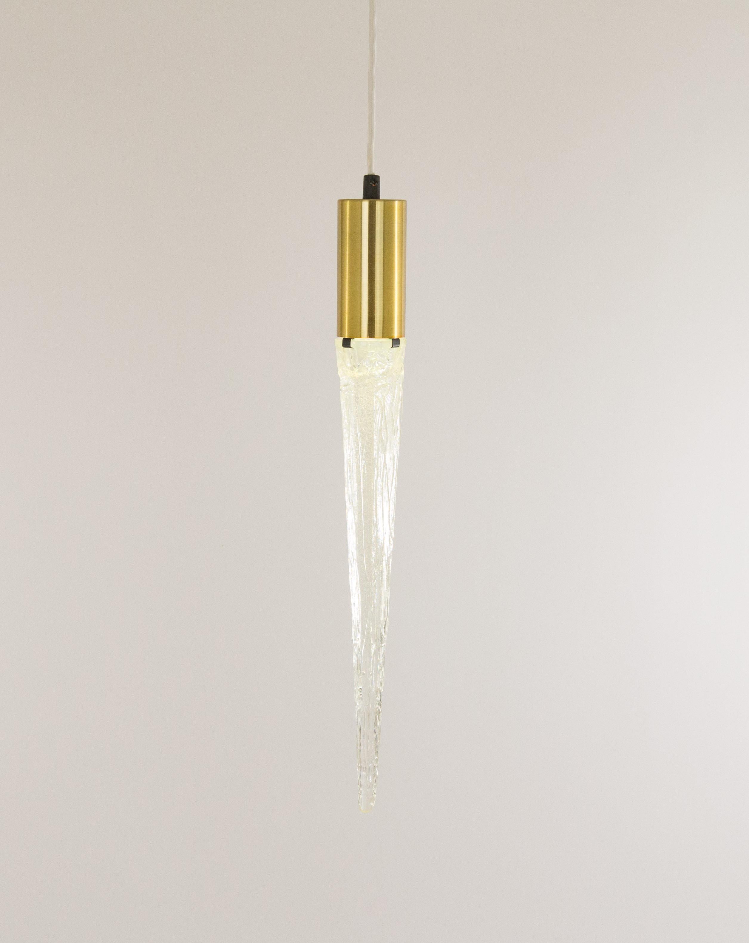 Surprising pendant in the form of an icicle, made by the Danish lighting manufacturer Vitrika, probably in the 1960s.

The lamp features a brass body -that houses the bulb mount socket- and an acrylic part. The light from the bulb is transferred