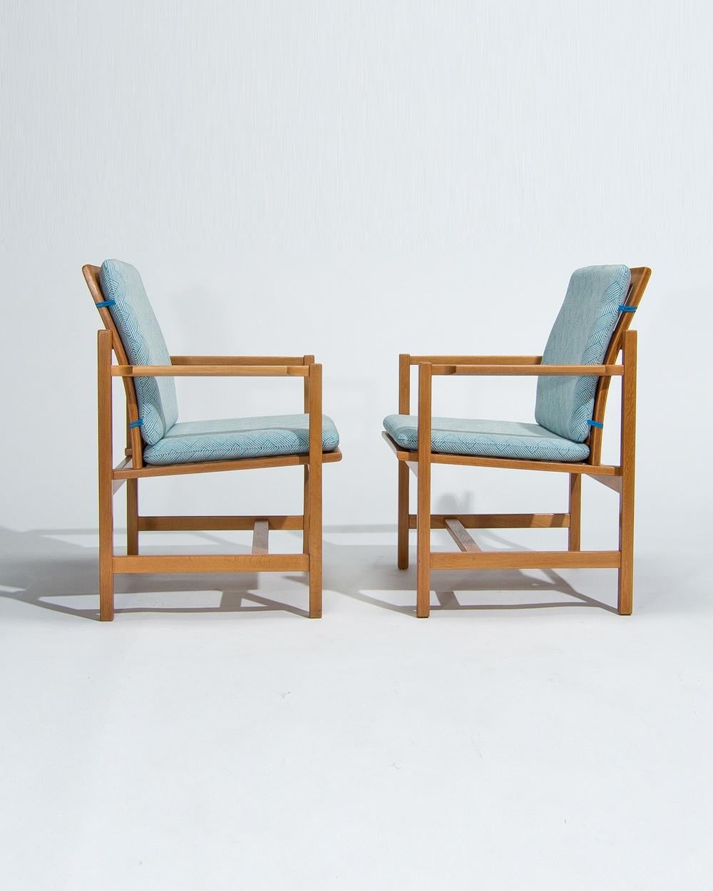 An attractive pair of mid century Danish armchairs designed by Borge Mogensen for Fredericia Stolefabrik in the 1960’s.  Beautifully crafted in Denmark the oak has lovely colour and patina and is complemented nicely by the new cushions in a Colefax