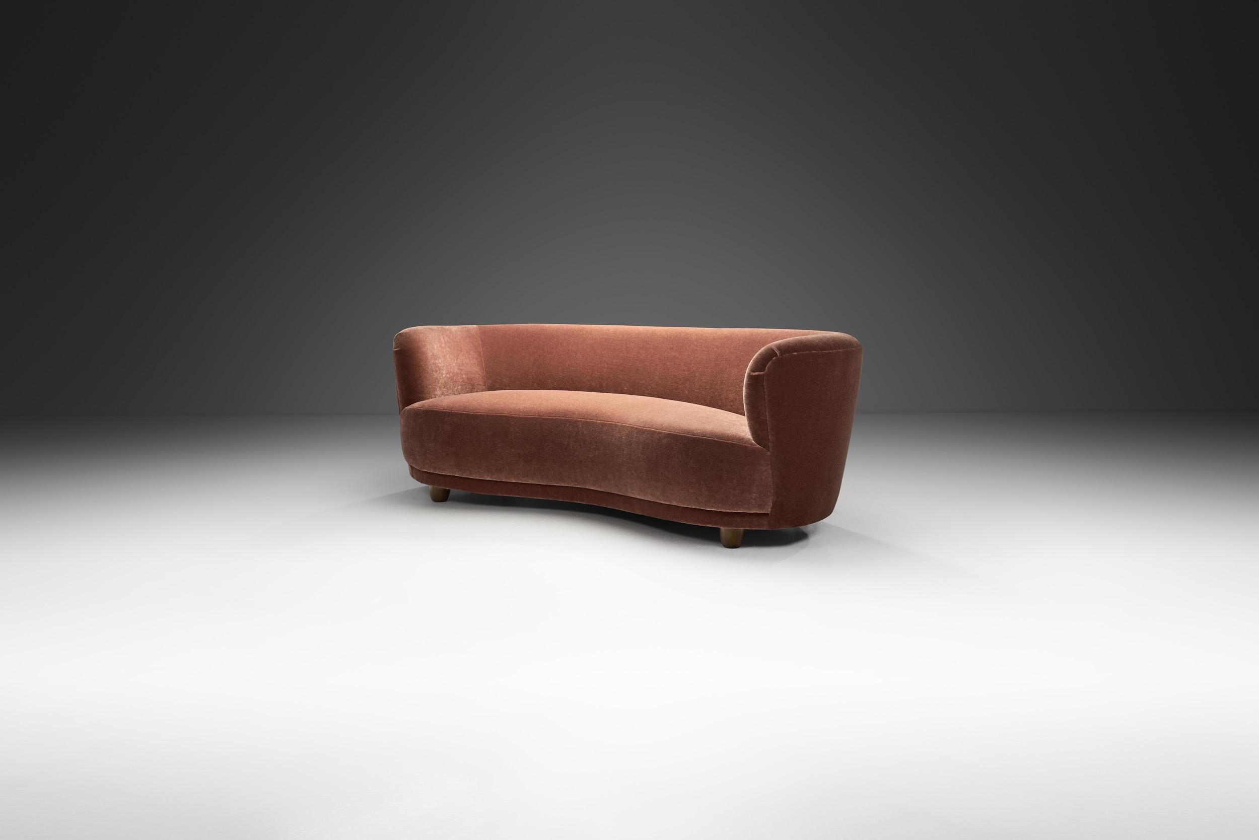 This beautiful Danish three-seater sofa recalls the Art Deco style of the 1930s with the recognizable touch of Danish Modernism. Thanks to its elegantly curved shape, this type of sofa is often referred to as the “banana” style, which not only