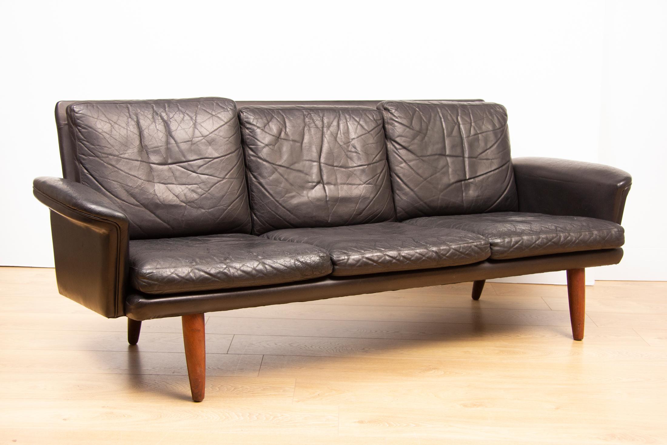 Midcentury Danish black leather sofa three-seat with age related wear, no holes or tears.