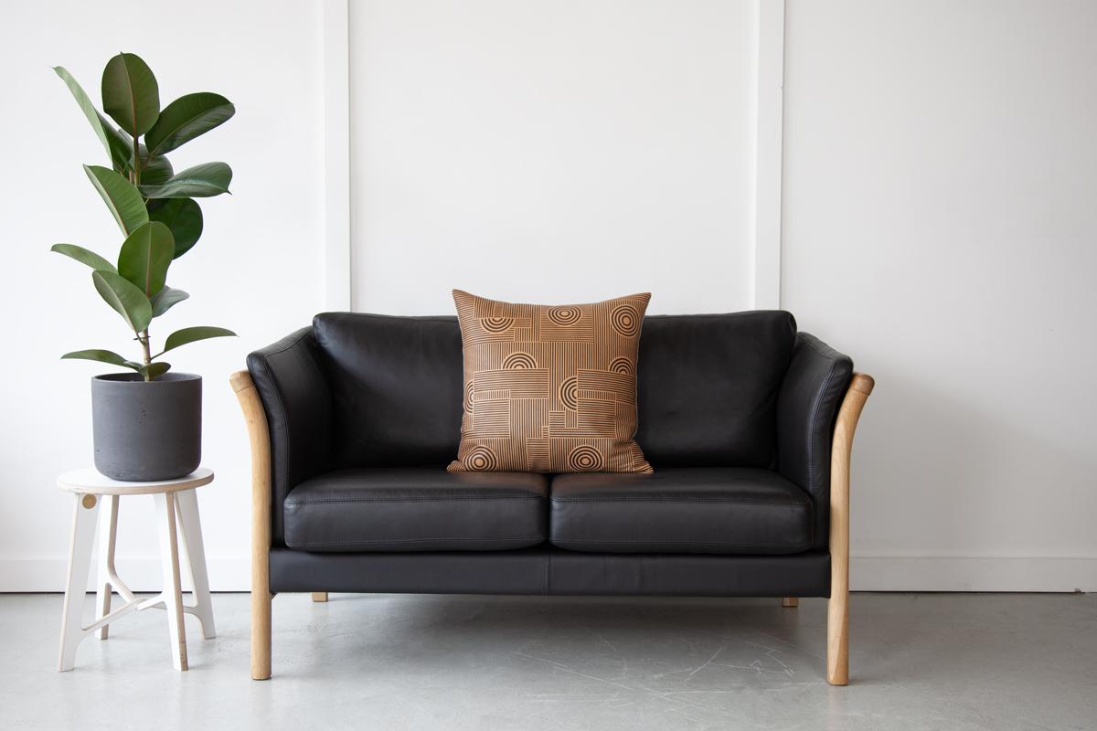 An elegant, black leather two-seater sofa manufactured by Mogens Hansen, Stouby with a pleasing beech frame and quality aniline leather cushions. 