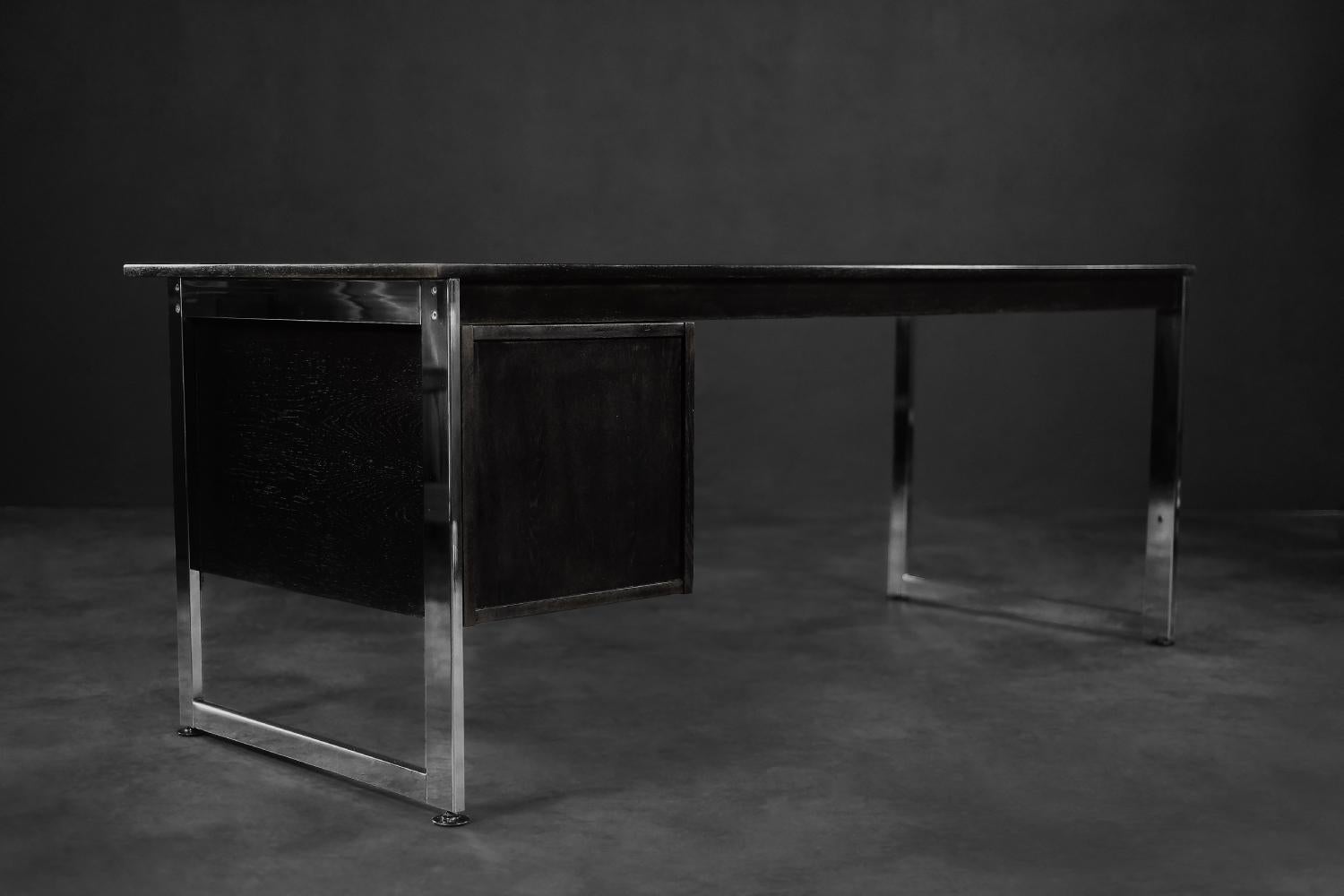 Dieser minimalistische Bürotisch wurde in den 1970er Jahren in Dänemark hergestellt. Der Schreibtisch zeichnet sich durch klare Linien aus und schafft eine harmonische Komposition der verwendeten Materialien. Die große Platte und das Paneel mit den