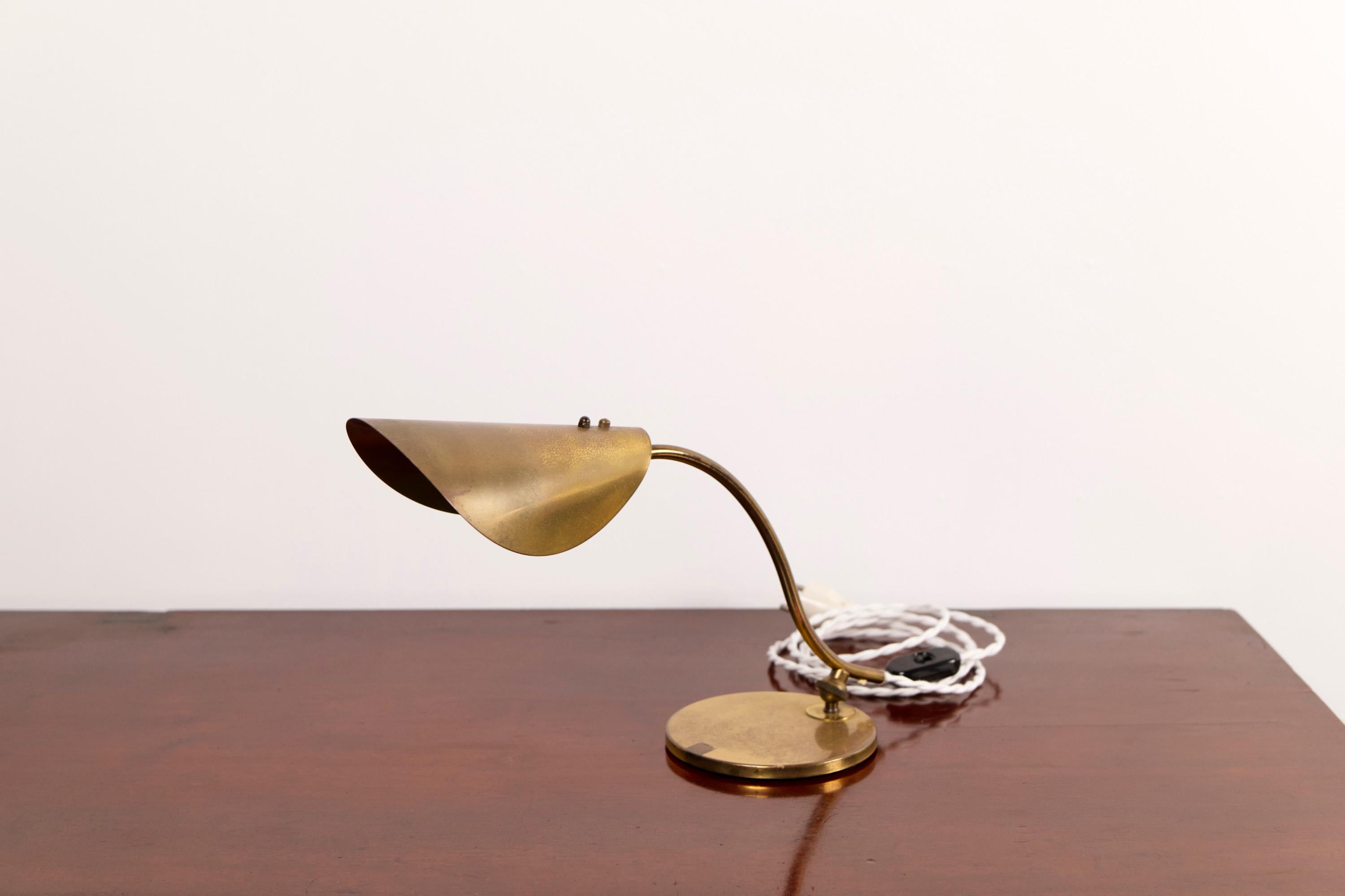 This mid-century Danish piano lamp features a beautifully sculpted, leaf-inspired brass shade and an adjustable arm, allowing you to direct light precisely where needed—perfect for use on a piano, desk, or sideboard. Its minimalist design is