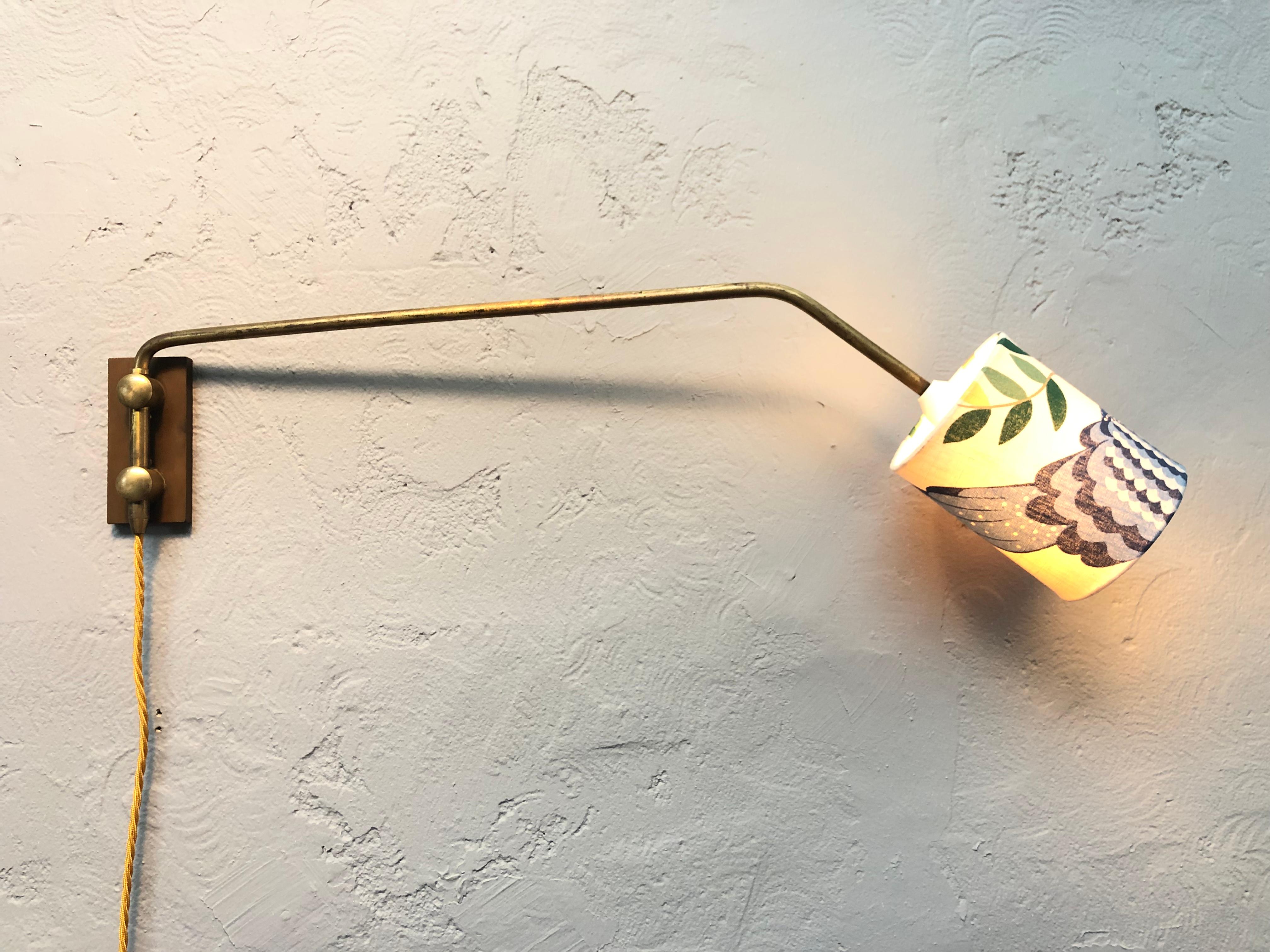 A Danish midcentury brass wall lamp by Fog And Morup. 
Lovely patina to the brass. 
An original lampshade that has been refurbished with beautiful vintage fabric entitled “Birdland” by Ann-Christin Sigrid. 
Original white Bakelite bulb holder