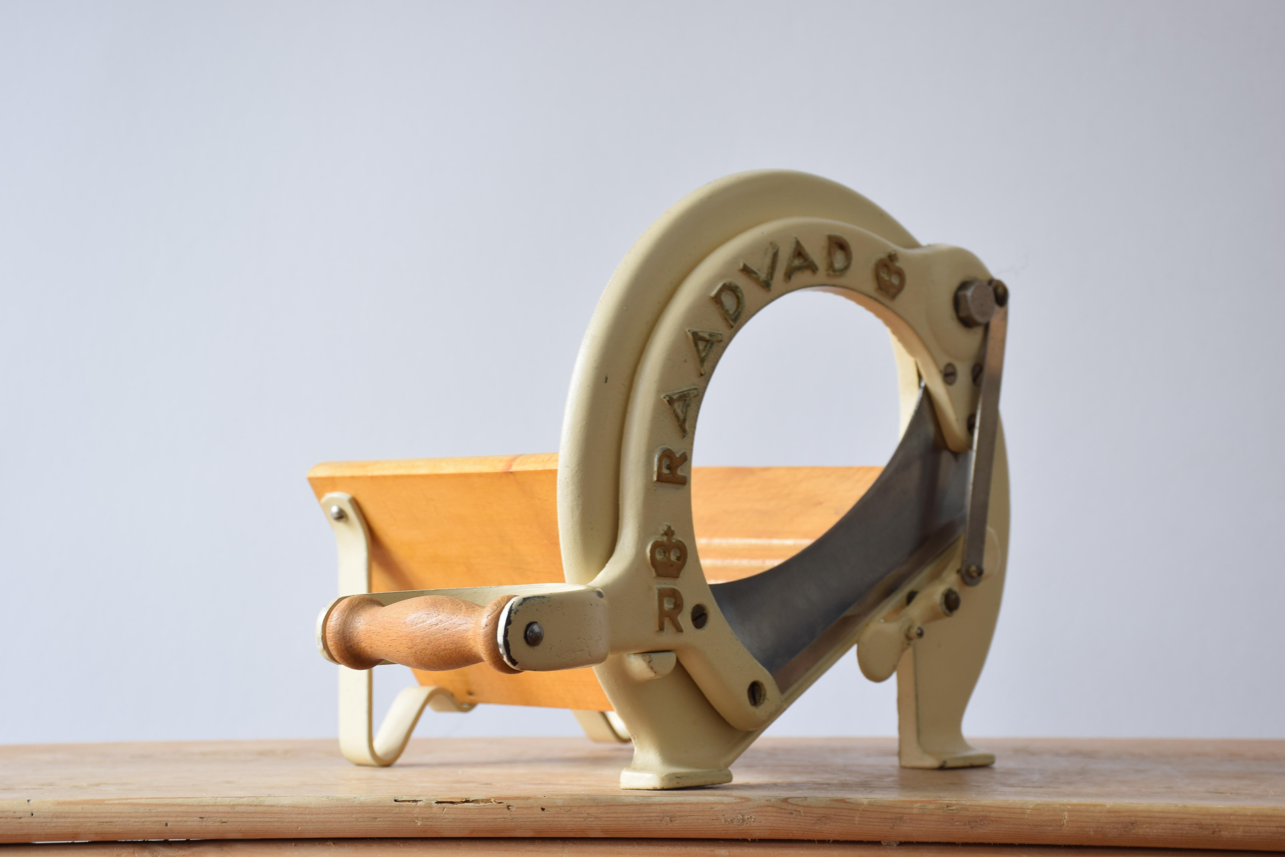 This iconic Danish bread slicer was produced by Raadvad in Denmark circa 1940s-1960s and designed in the 1930s. It comes with original beige lacquer and original golden letters. The bread slicer is fully functional for slicing bread, especially