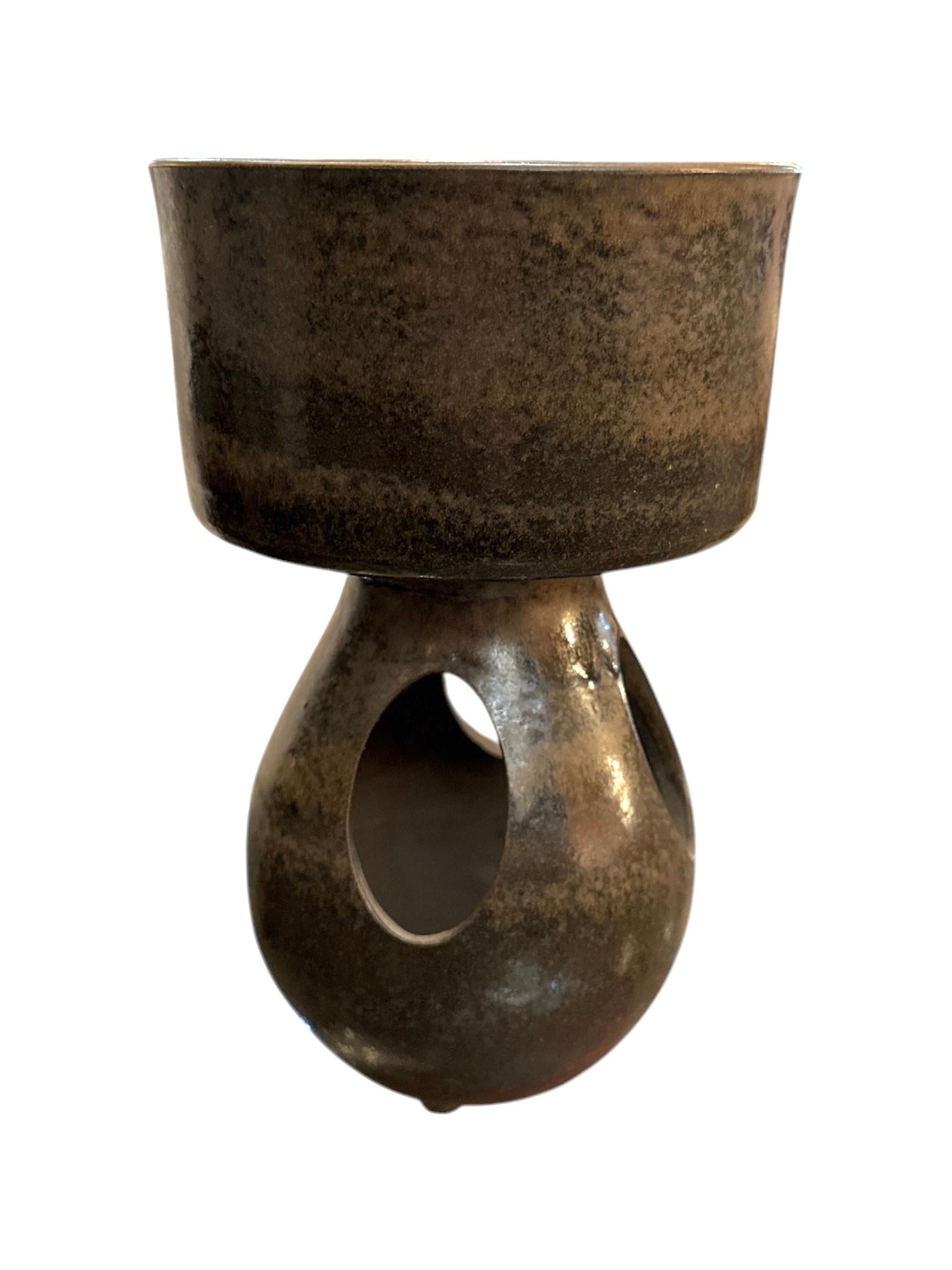 Questo vaso in ceramica danese del Mid-Century incarna l'eleganza minimalista dell'epoca del design degli anni '50. Realizzata in ceramica di alta qualità, la sua forma elegante e semplice è esaltata da smalti sottili e toni della terra che evocano