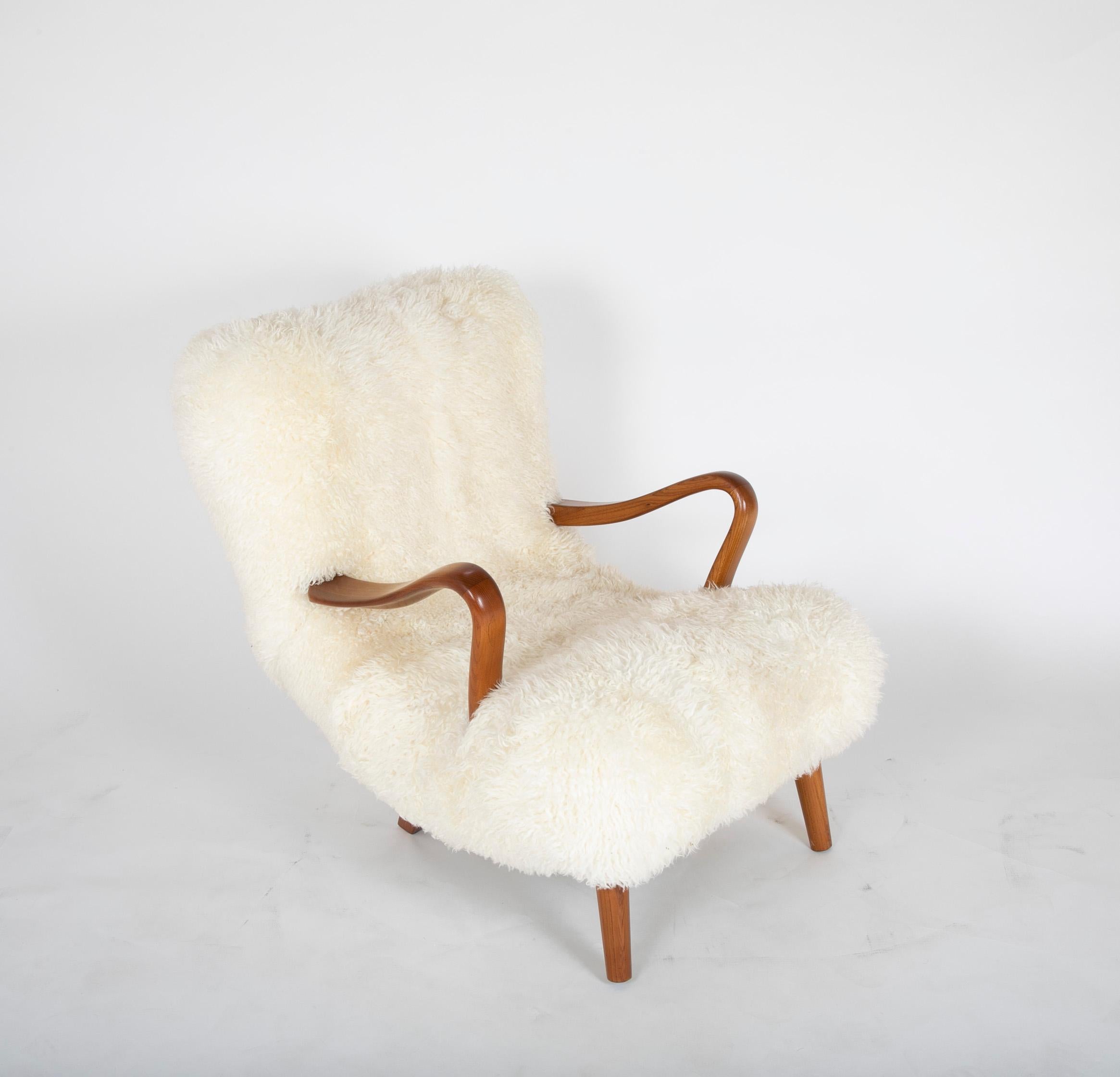 Midcentury Danish easy chair of elm wood covered in long haired sheepskin.