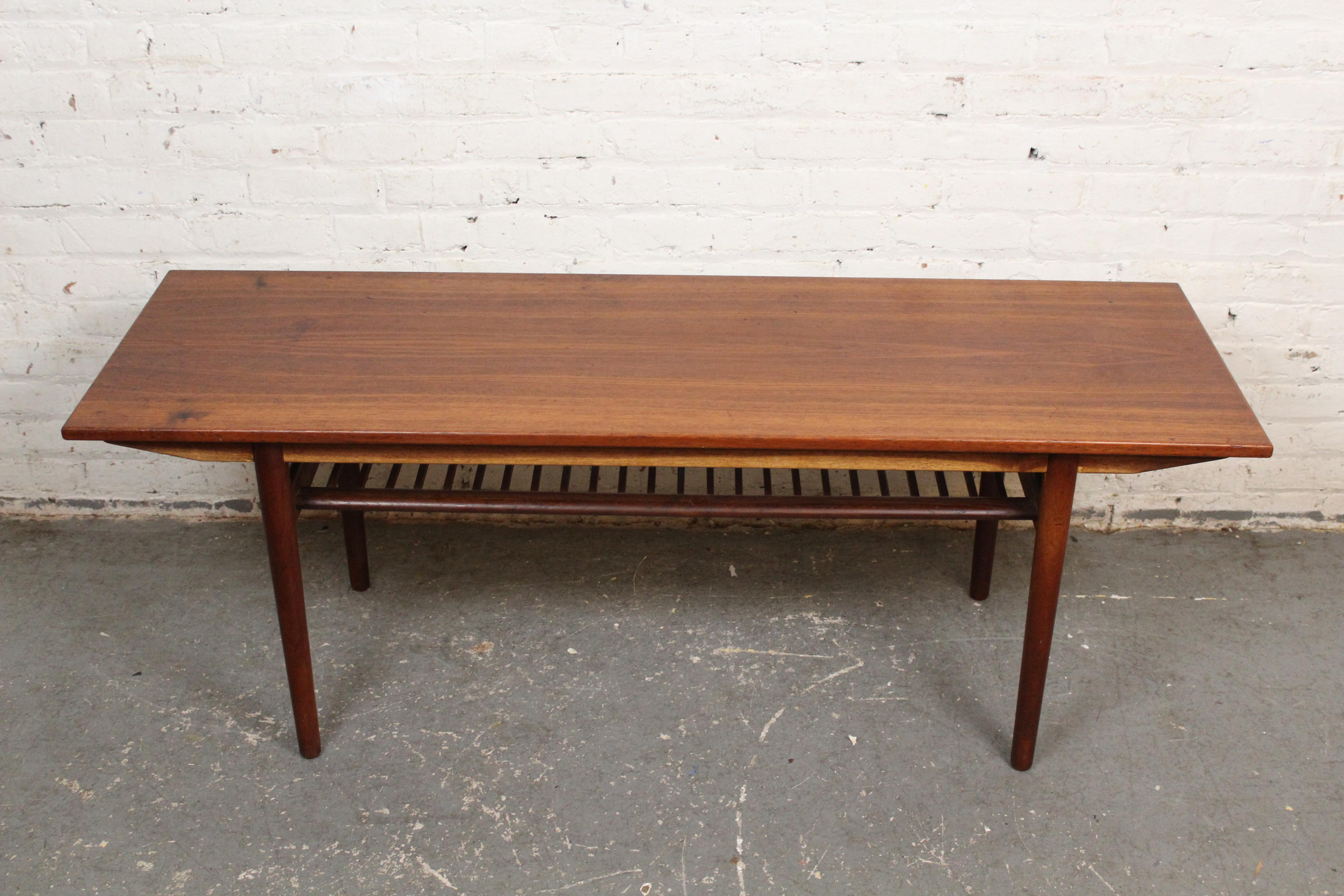 Exemple frappant du design scandinave du milieu du siècle, cette table basse vintage a été conçue au Danemark par le célèbre architecte Arne Hovmand/Olsen pour Jutex. Fabriquée en bois de teck richement grainé, la table présente une silhouette