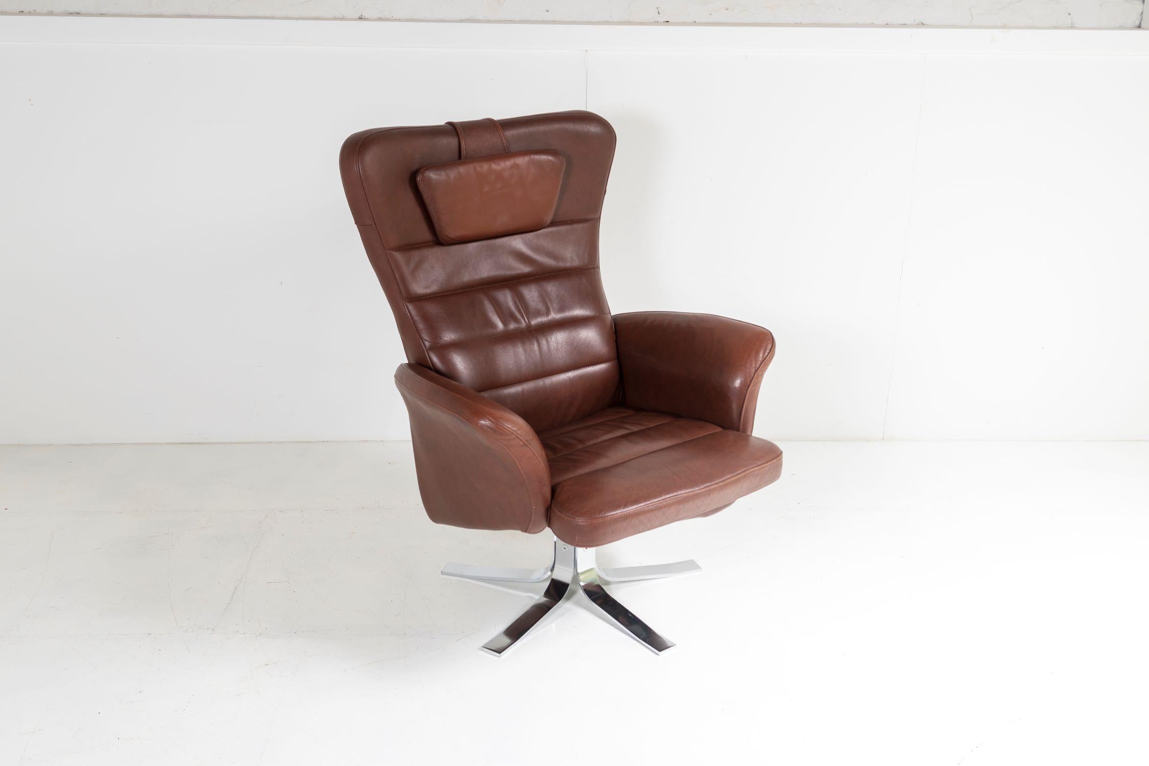 A stylish mid century brown leather Swivel chair on heavy chrome base. A large chair with good proportion, egg shaped in design with sweeping curved arms, attractive design from the back too with a seem running up the centre. Includes a small loose