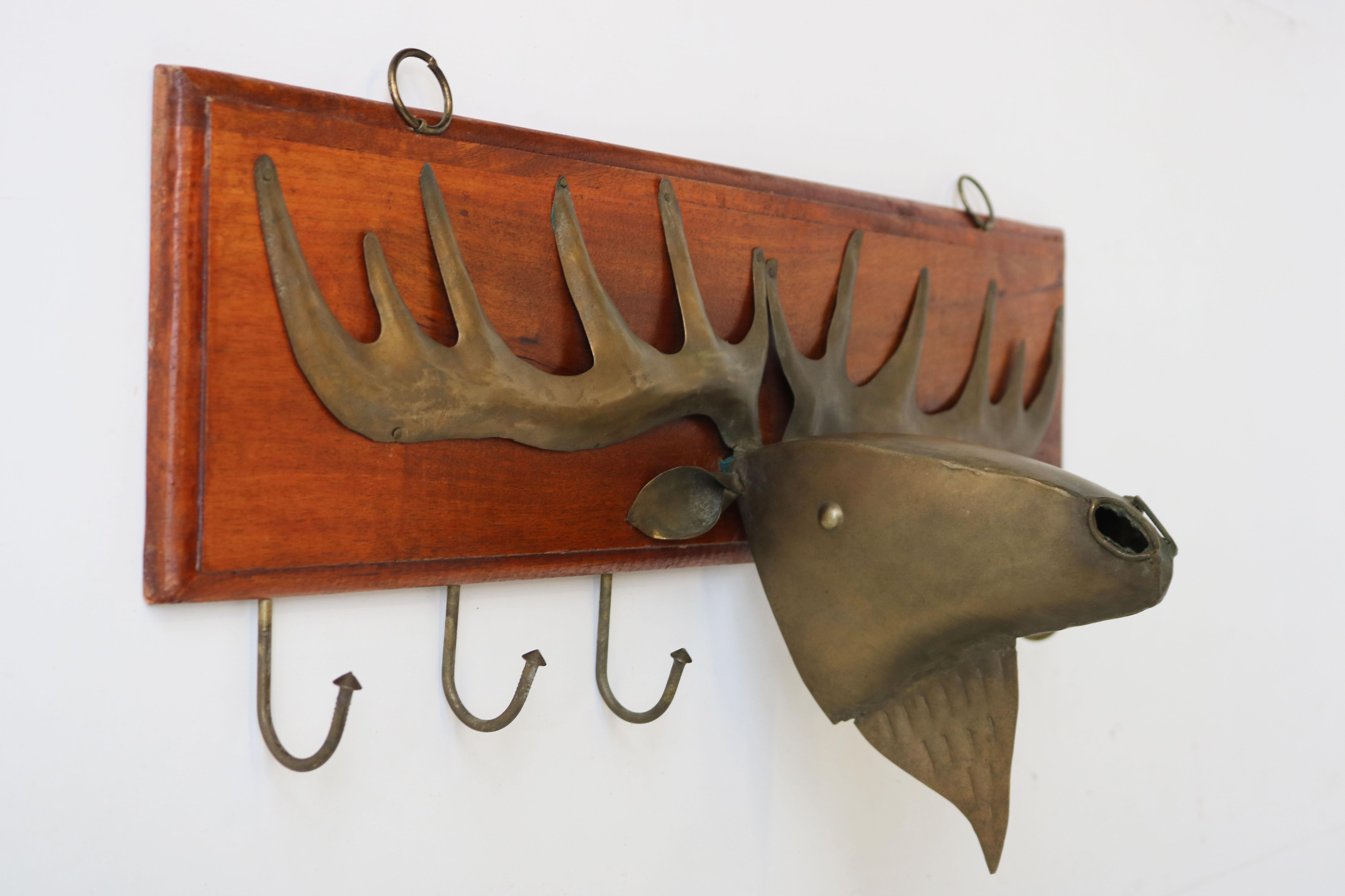 Marvelous mid-century danish design piece! This teak coat rack with large Moose sculpture in brass. 
Made with much attention to detail, the moose sculpture, hooks & rings are all hand forged. 
A lovely piece for your hallway or kitchen! The teak