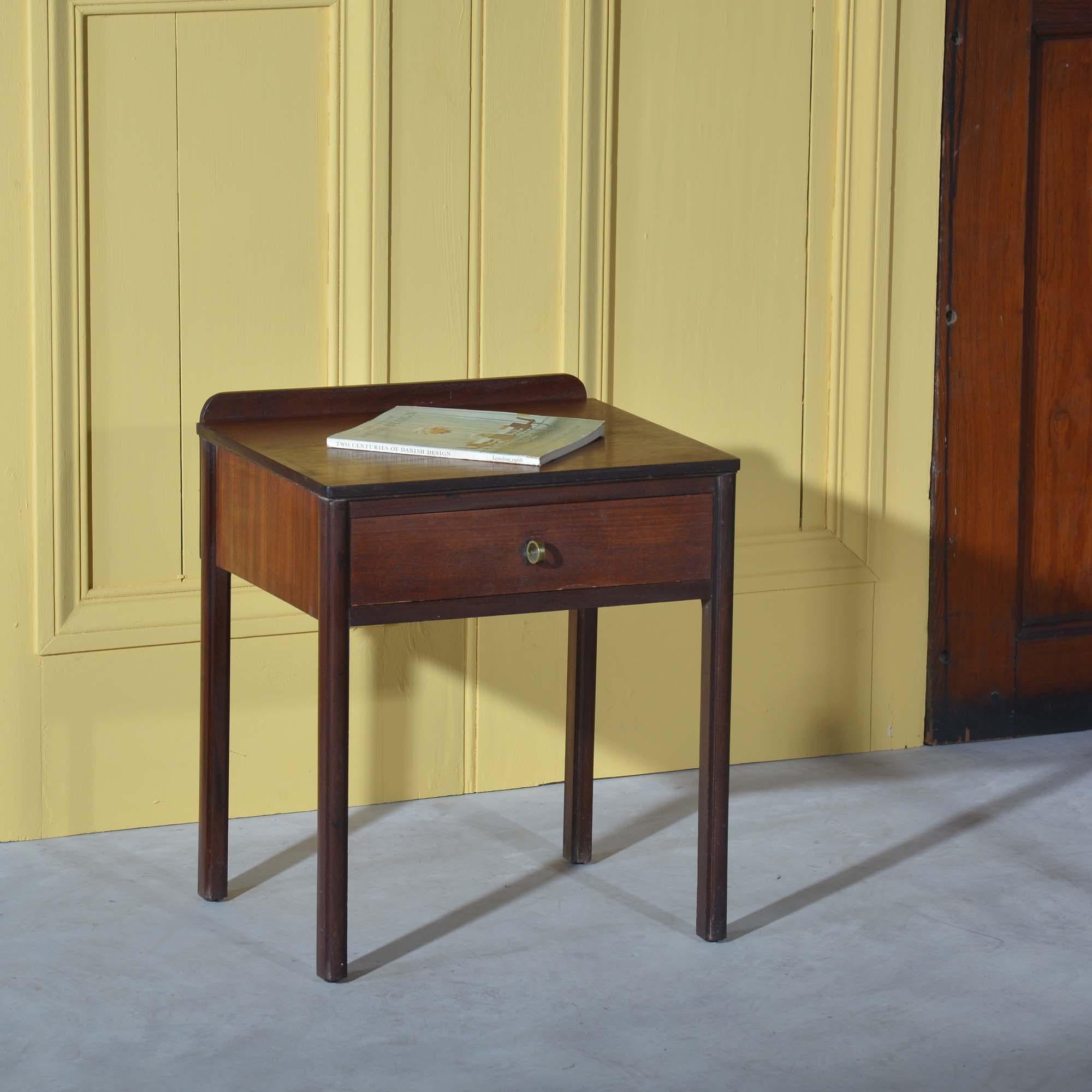 Nachttisch aus Teakholz im dänischen Design der Jahrhundertmitte
Nachttisch aus Teakholz mit einer Schublade und markantem Messingrohrgriff. Wiederverkauft bei Heals & Co.
Dänisch, um 1960