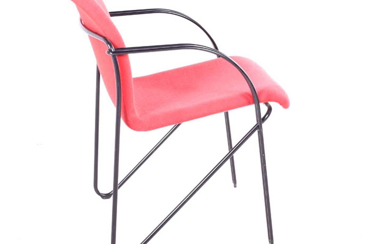 This Mid Century Danish chair captures the essence of Danish design, characterized by its simplicity, functionality, and a pop of vibrant color. The chair’s structure is formed from metal, lacquered in a sleek black finish that gives it a