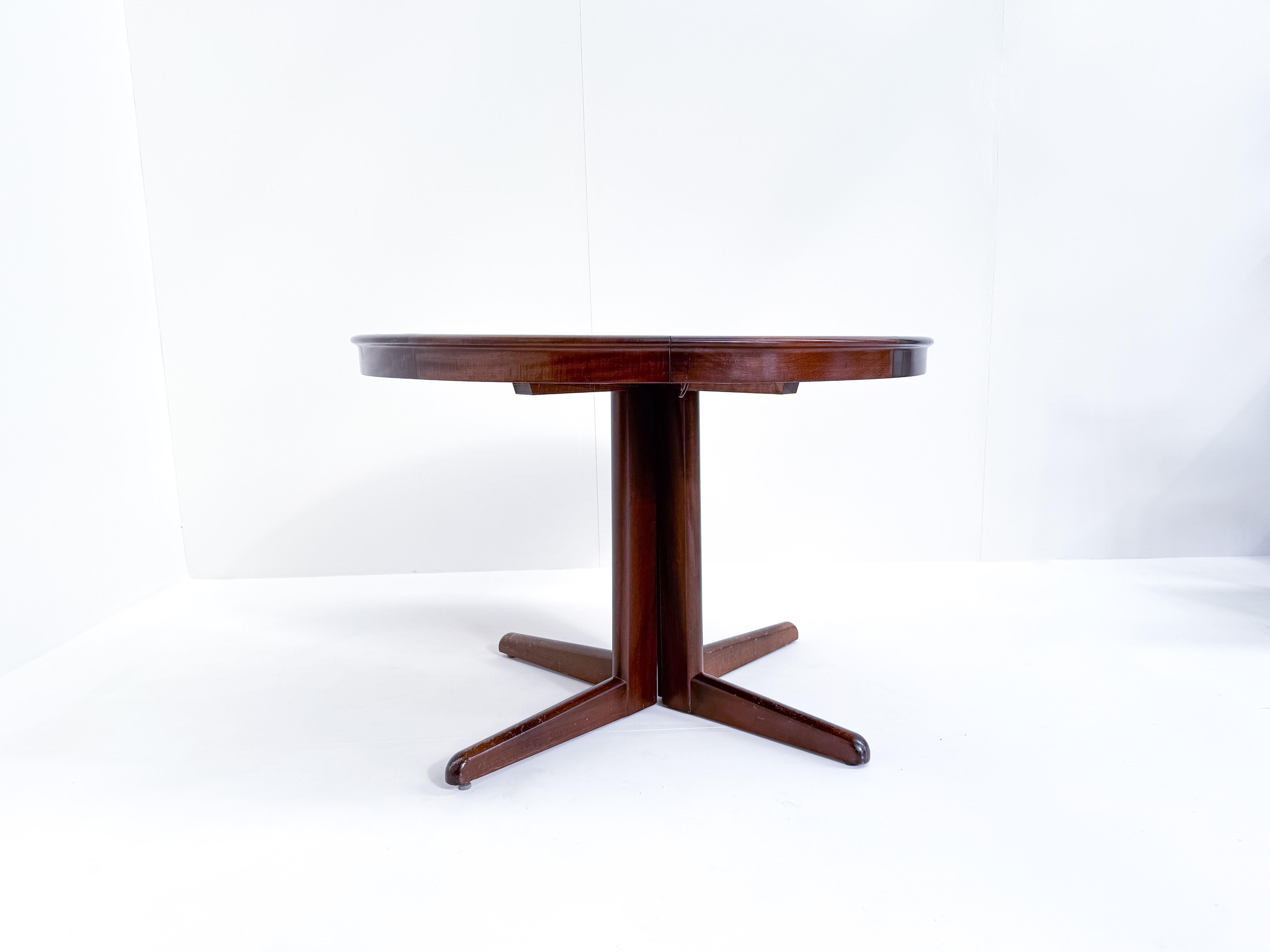 This stunning mid-century dining set by H.W. Klein for Bramin is a fine example of Danish craftsmanship and timeless design. The round mahogany table comes with two extension leaves, allowing it to expand into an elegant oval shape, ideal for