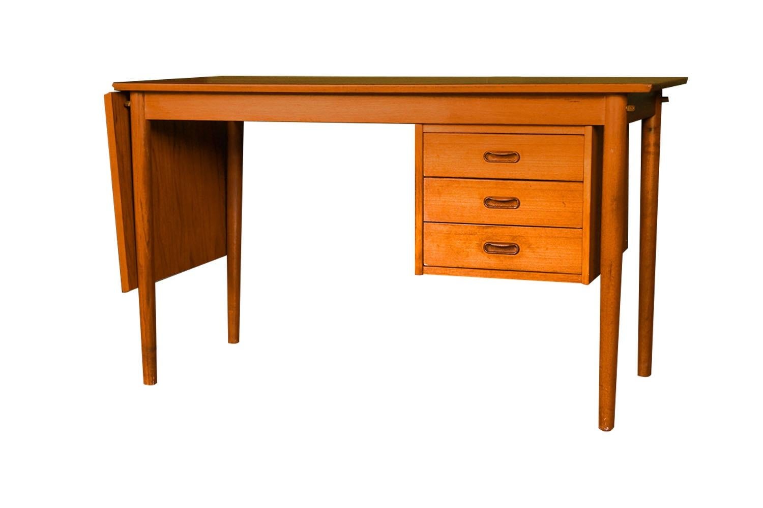 A desk with incredible form and presence. This rare most attractive original Danish Modern drop leaf desk by Arne Vodder (1926-2009) designed for Sibast Mobler in Denmark, features a drop leaf frame with floating hanging triple drawer storage