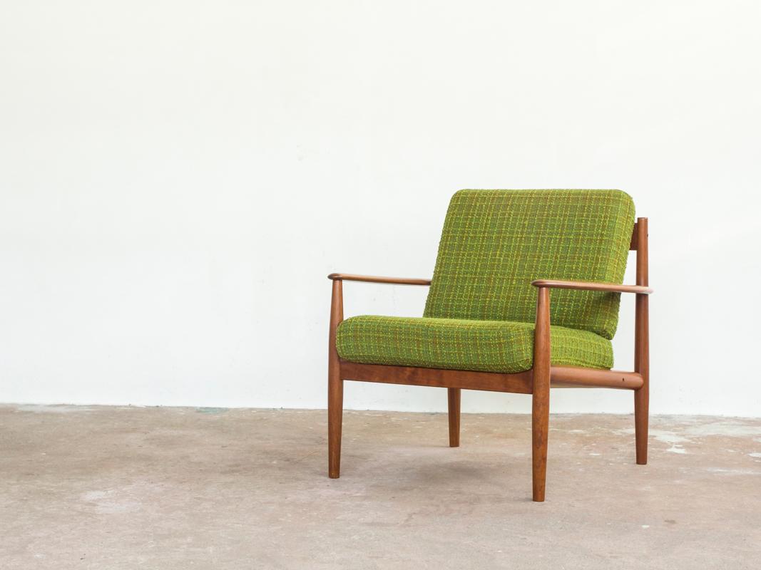 Mid-century easy chair designed by Grete Jalk and manufactured by France & Søn in Denmark in the 1960s. The easy chair is labelled by the manufacturer. It is made of solid teak and has the orignal cushions with springs covered with green fabric. All