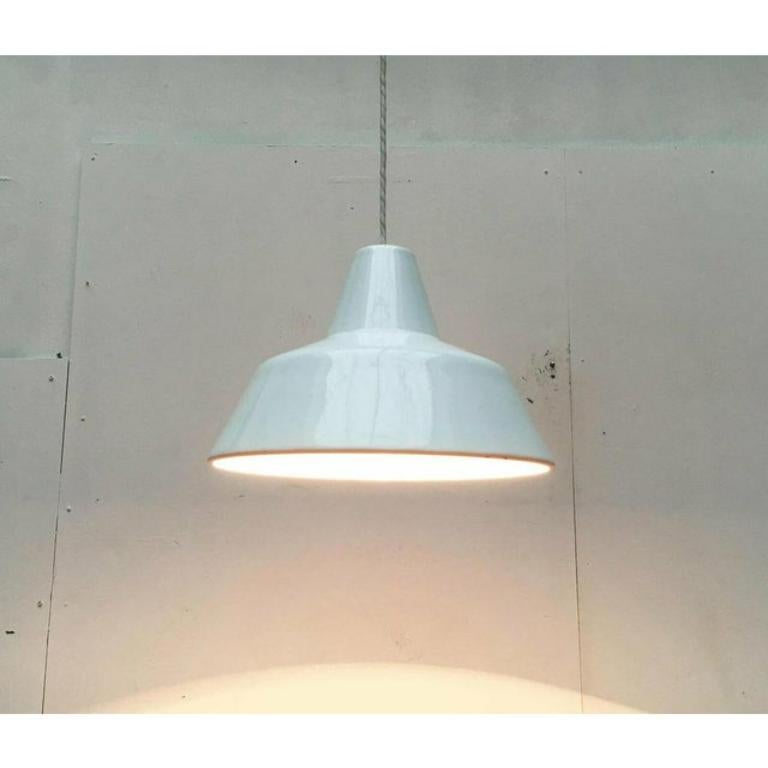 Semplice lampada a sospensione smaltata in bianco del produttore danese Louis Poulsen. Conosciuta anche come scuola di smalto o Arbejd spendula.

Un design archetipico. Pendolo funzionale nella classica forma di una lampada industriale o da