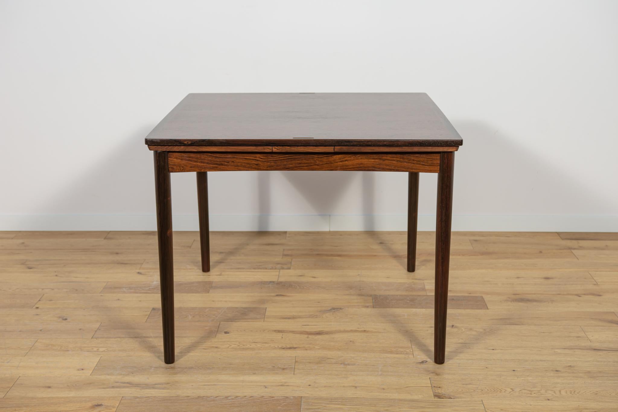 Cette table à rallonge carrée en bois de rose a été fabriquée au Danemark dans les années 1960. La table a des bords renforcés et profilés. La table de salle à manger a été entièrement rénovée, nettoyée des anciens revêtements, peinte avec de la