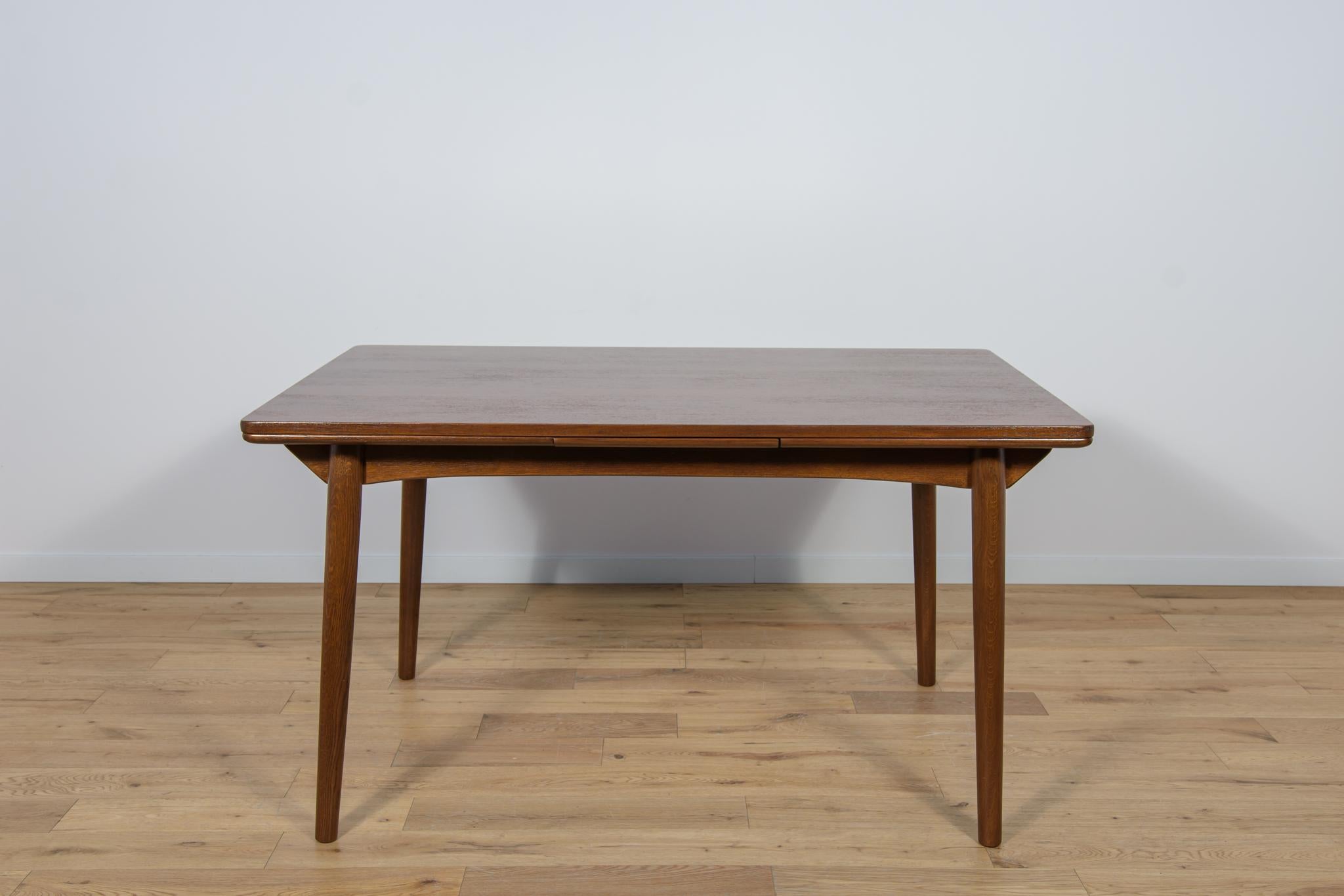 The extendable tea wood table was produced in Denmark in the 1960s.The furniture has been completely renovated, cleaned of the old coating, painted with rosewood stain, finished with a strong semi-matte varnish. The table extends through two