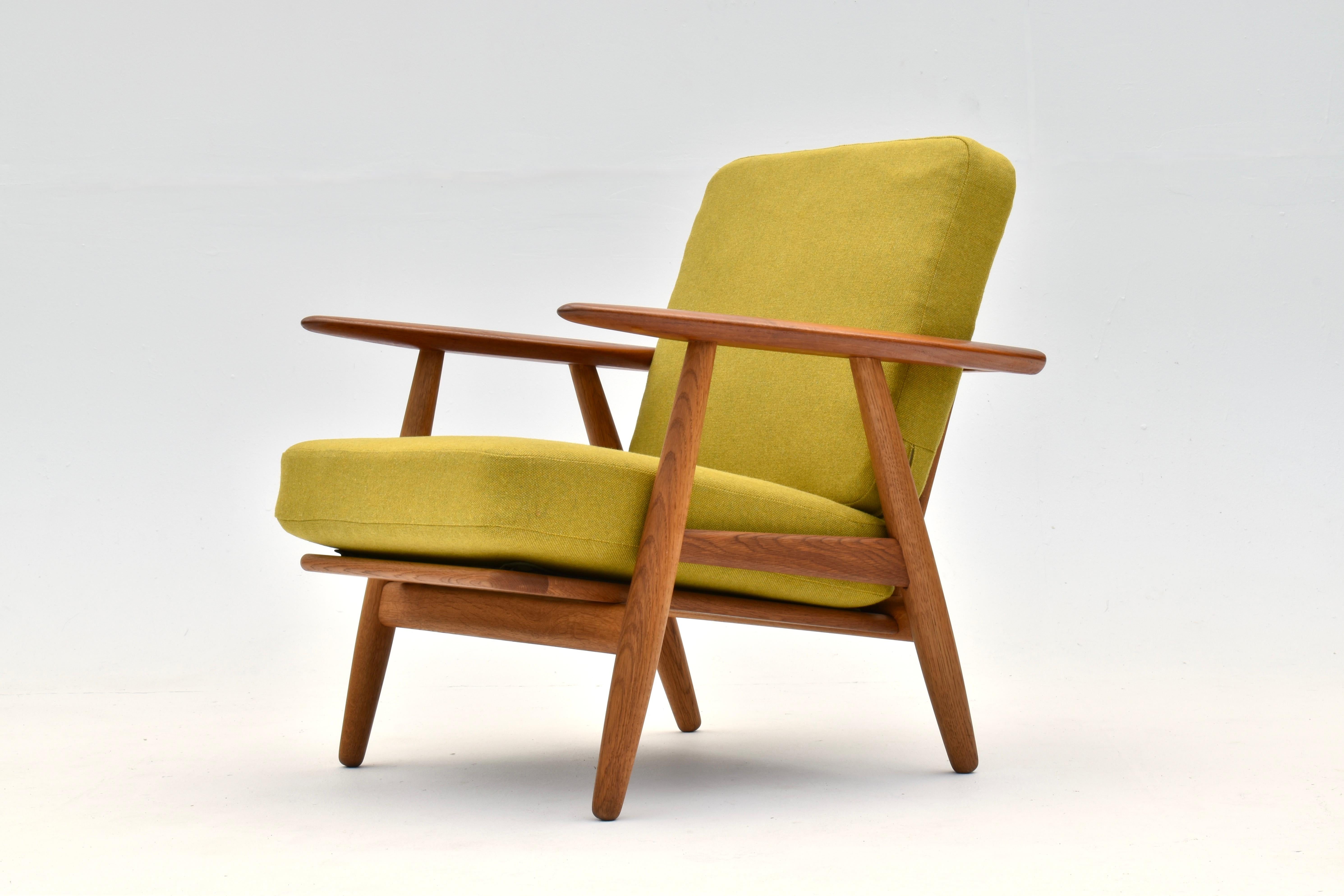 Design classique de 1954 du maître de la modernité danoise, Hans Wegner.

Structure en chêne massif avec accoudoirs contrastés en teck. Ressort en acier d'origine  Les coussins sont recouverts d'une laine tweed de haute qualité, très proche des