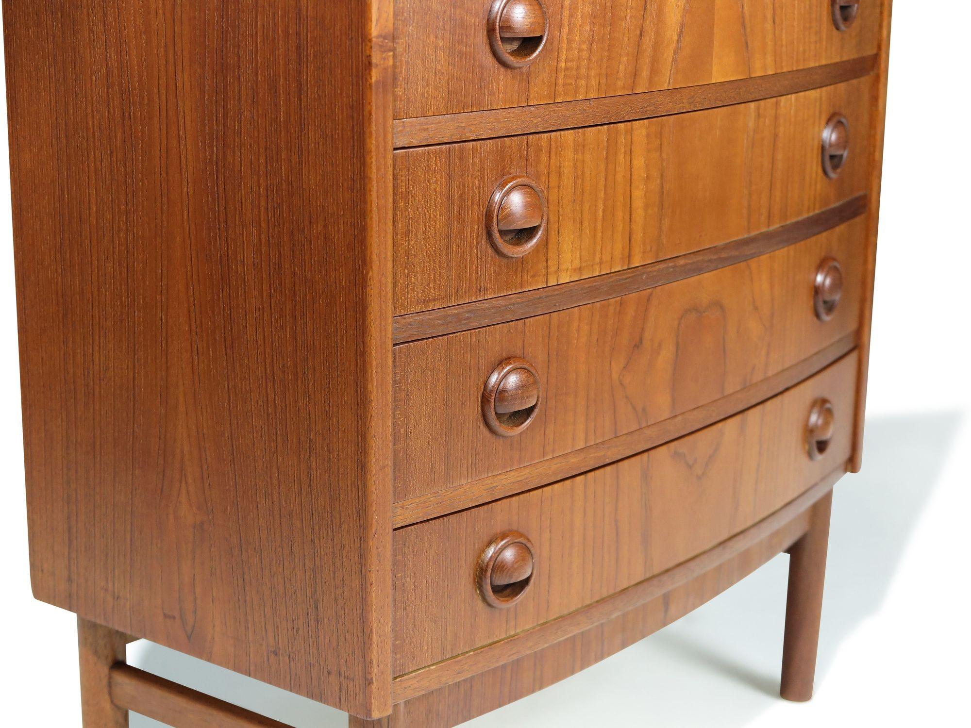 Small Danish nightstand or entry chest designed by Kai Kristiansen for Feldballes Møbelfabrik, circa 1963. The design features a bowed front, mitered corners, and pattern-matched drawer fronts, each fitted with circular carved pulls. The chest