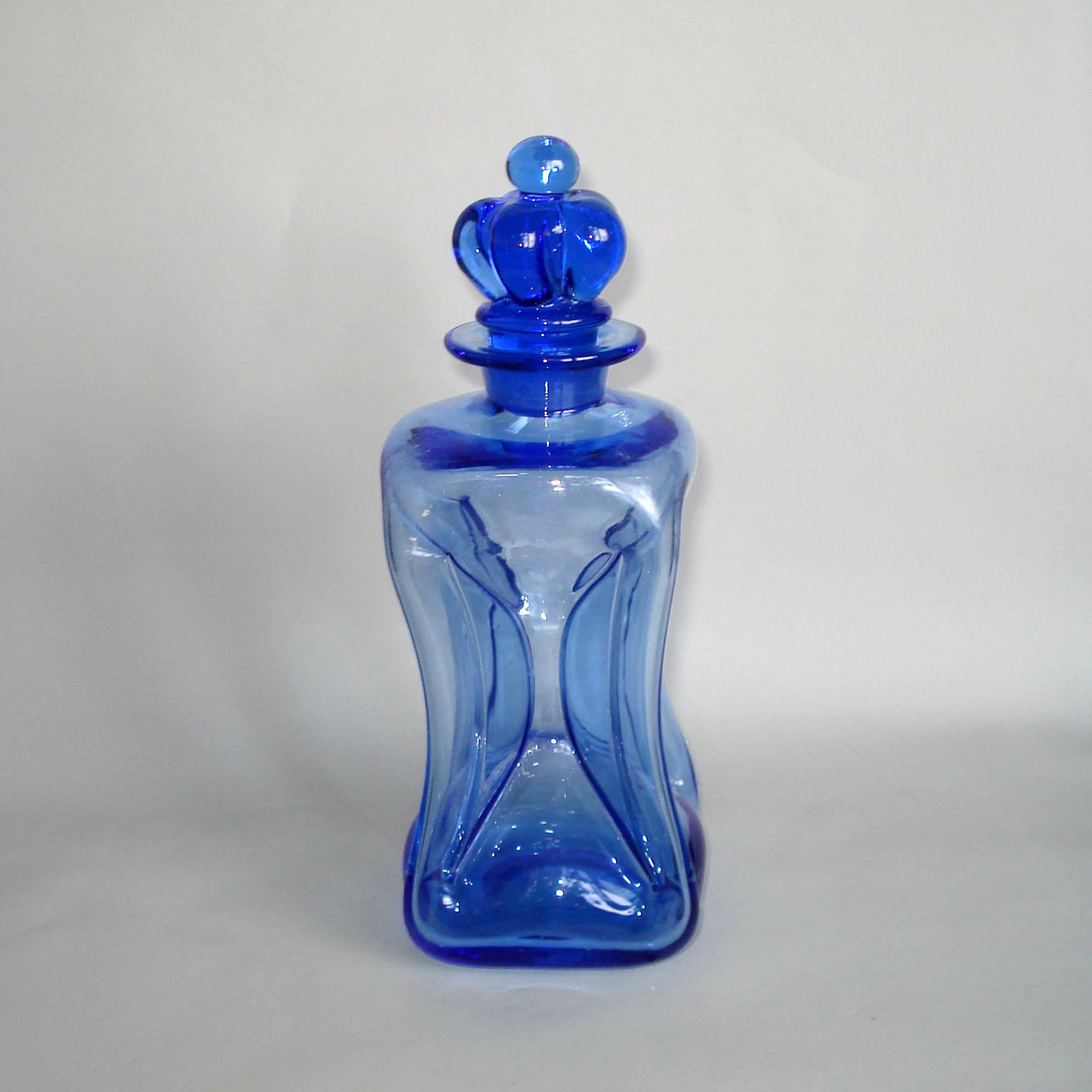 Midcentury Danish glass decanter designed by Jacob E. Bang for Holmegaard

A fine 1950s Danish royal blue decanter with crown stopper, designed by Jacob E. Bang for Holmegaard. Made of hand blown glass, with pinched side sections to create the