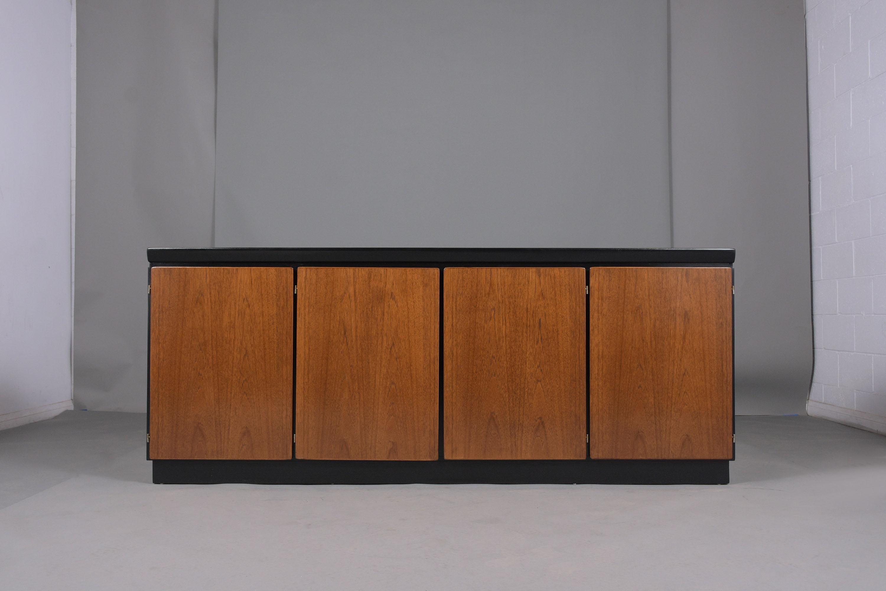 An extraordinary 1970s Skovby Møbelfabrik A/S 1 credenza handcrafted out of walnut wood stained in an elegant ebonized & walnut color and a newly lacquered finish by our professional team of in house craftsmen. This fabulous buffet has four push