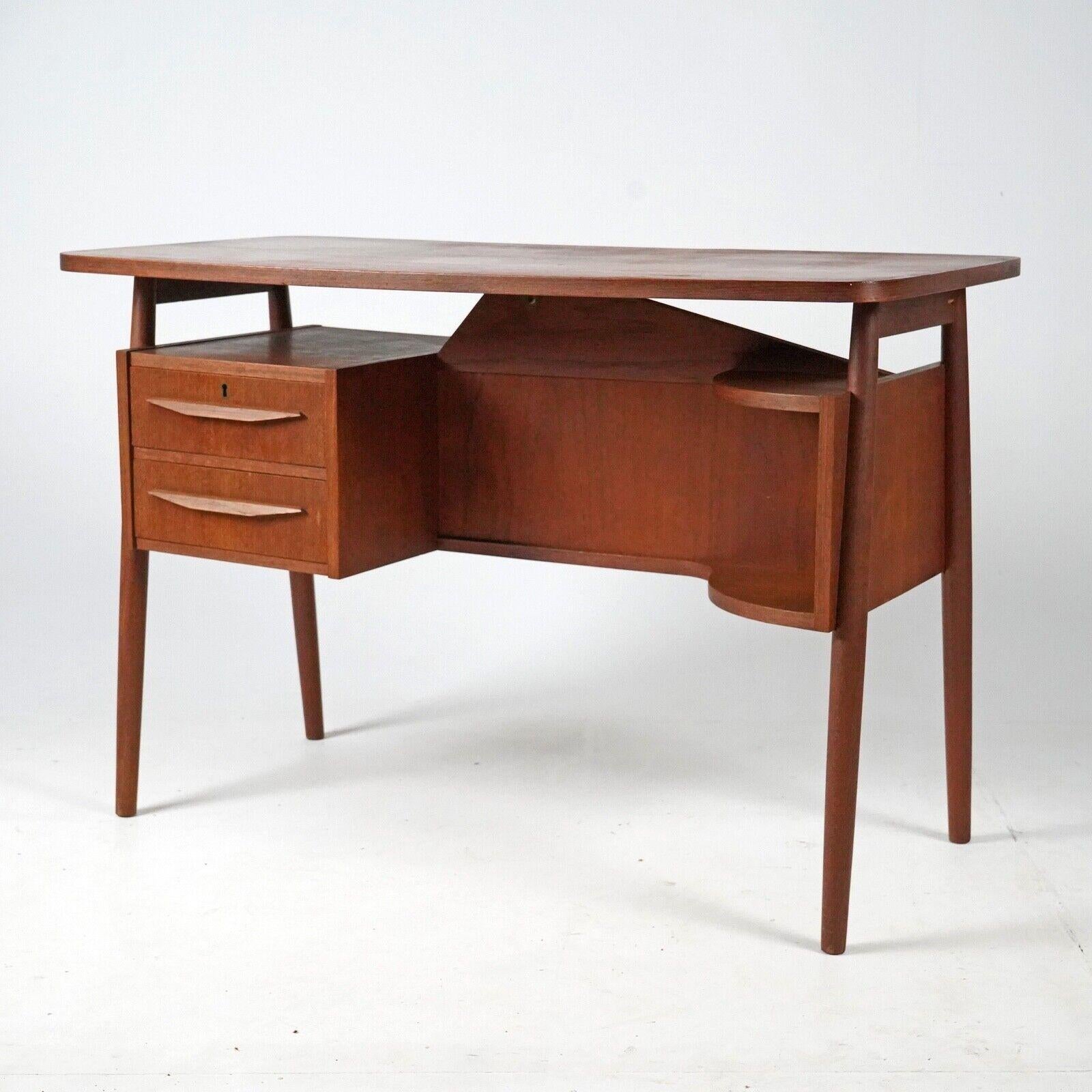 A well sized elegant desk 'Lady Desk' by Gunnar Neilson for Tibergaard. A great piece that has amble storage with two drawers and a rounded shelf on the front. On the back making it attractive from all angles is a further shelf/storage space. The